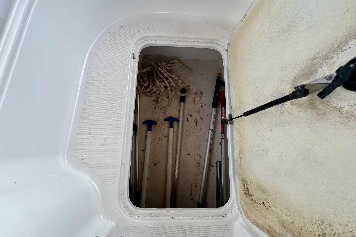 Storage compartment of 2013 Hurricane SunDeck 187 OB with ropes and poles.
