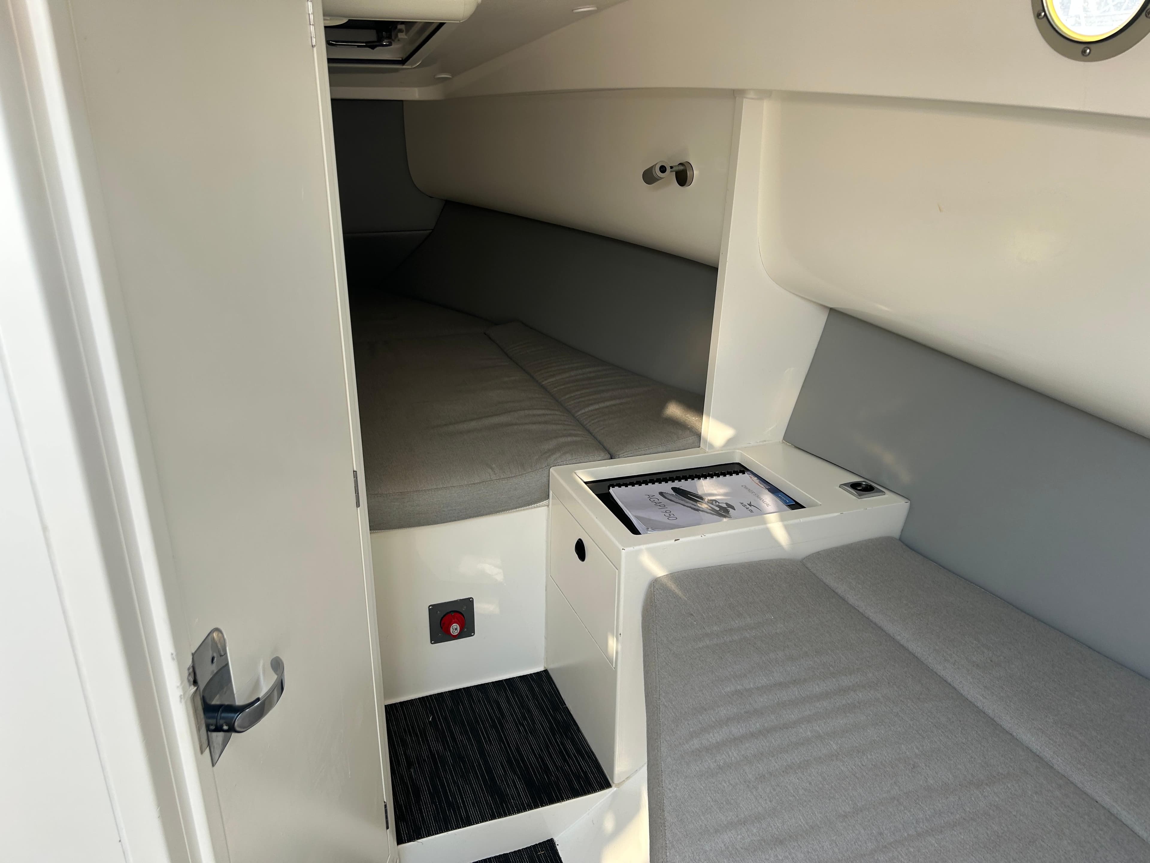 Interior cabin of 2017 Agapi 950 boat with gray seating and a small table.