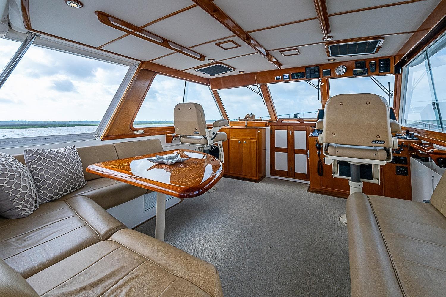 Luxurious interior of 2004 Grand Banks 49 Eastbay HX yacht with plush seating and elegant wood finishes.