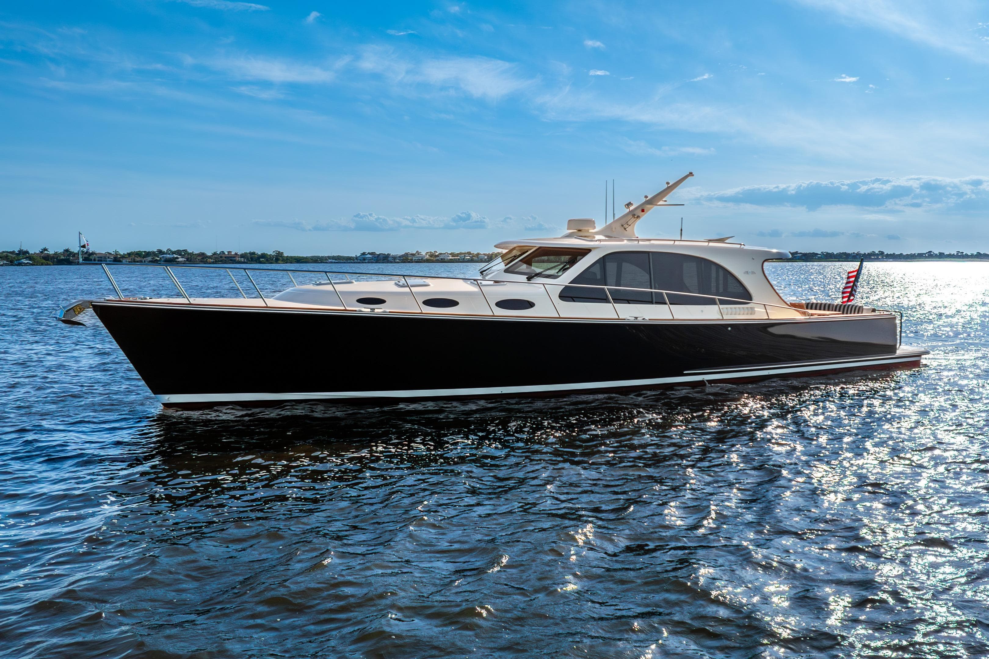 2020 Palm Beach Motor Yachts PB55 cruising on a sunny day, reflecting on the water.