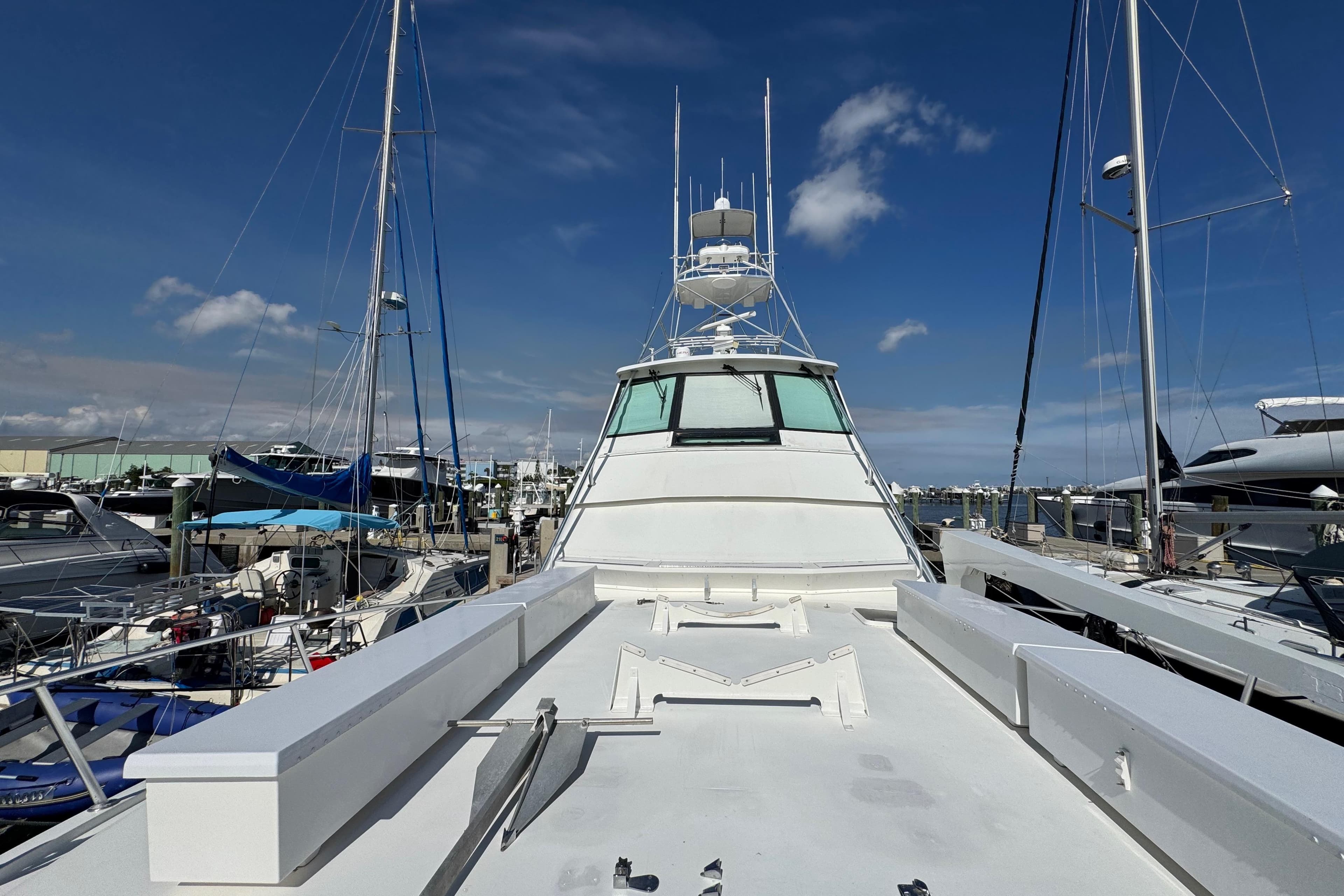 1995 Viking 58 Convertible yacht docked at marina under clear blue sky.