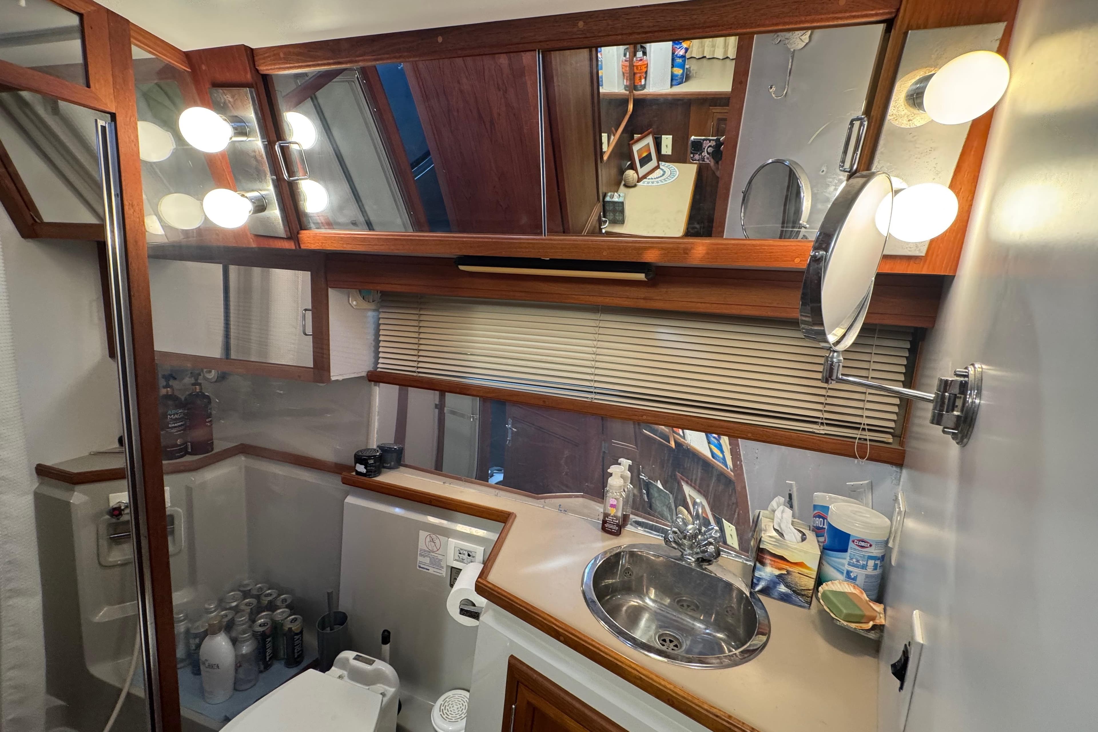 1986 Carver 42 Aft Cabin Motor Yacht bathroom with sink, mirror, and toiletries.