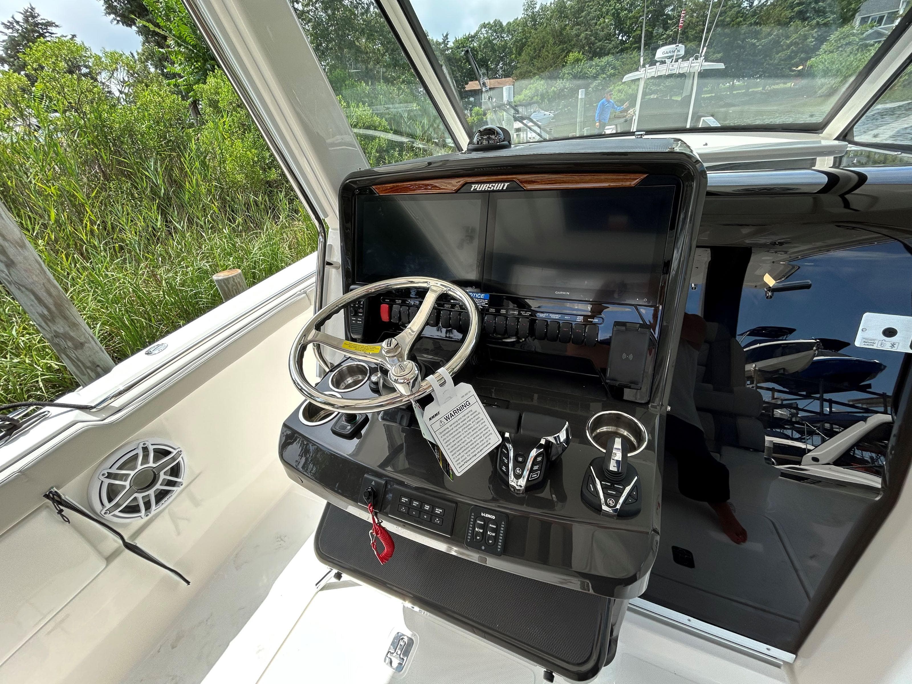2026 Pursuit S 328 boat helm with steering wheel and control panel.