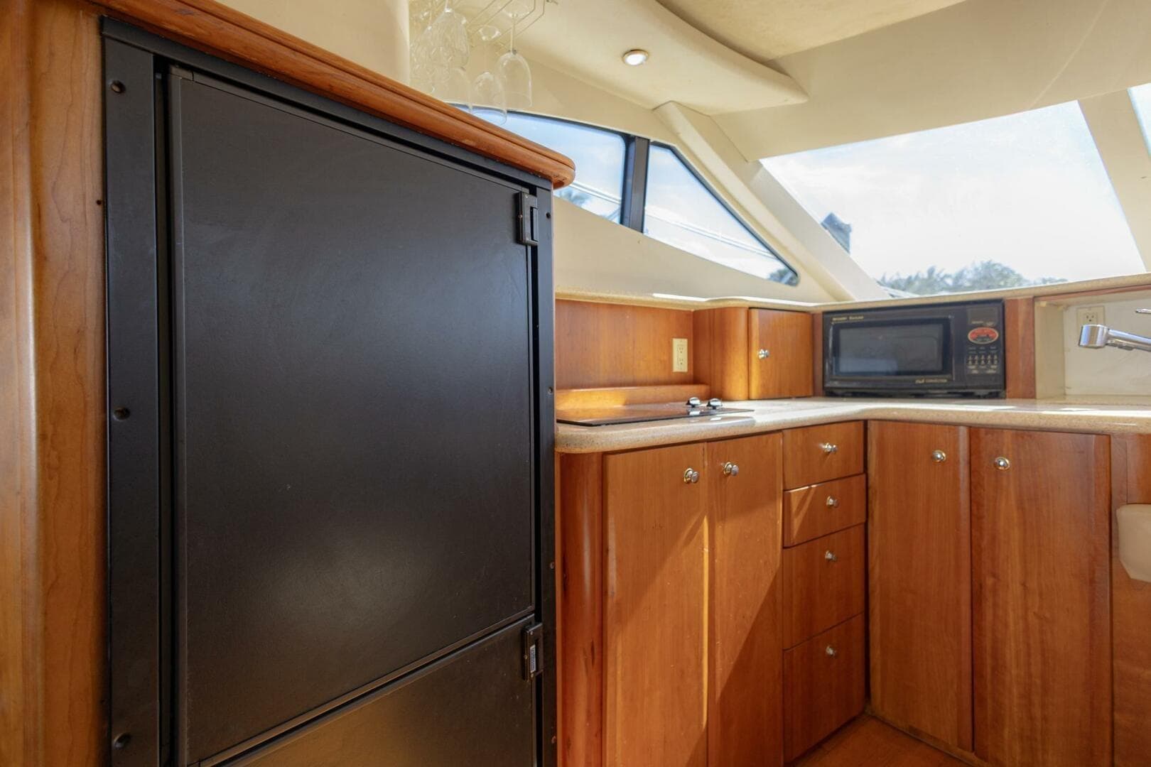 2001 Silverton 410 Sport Bridge yacht kitchen with wood cabinets, microwave, and refrigerator.