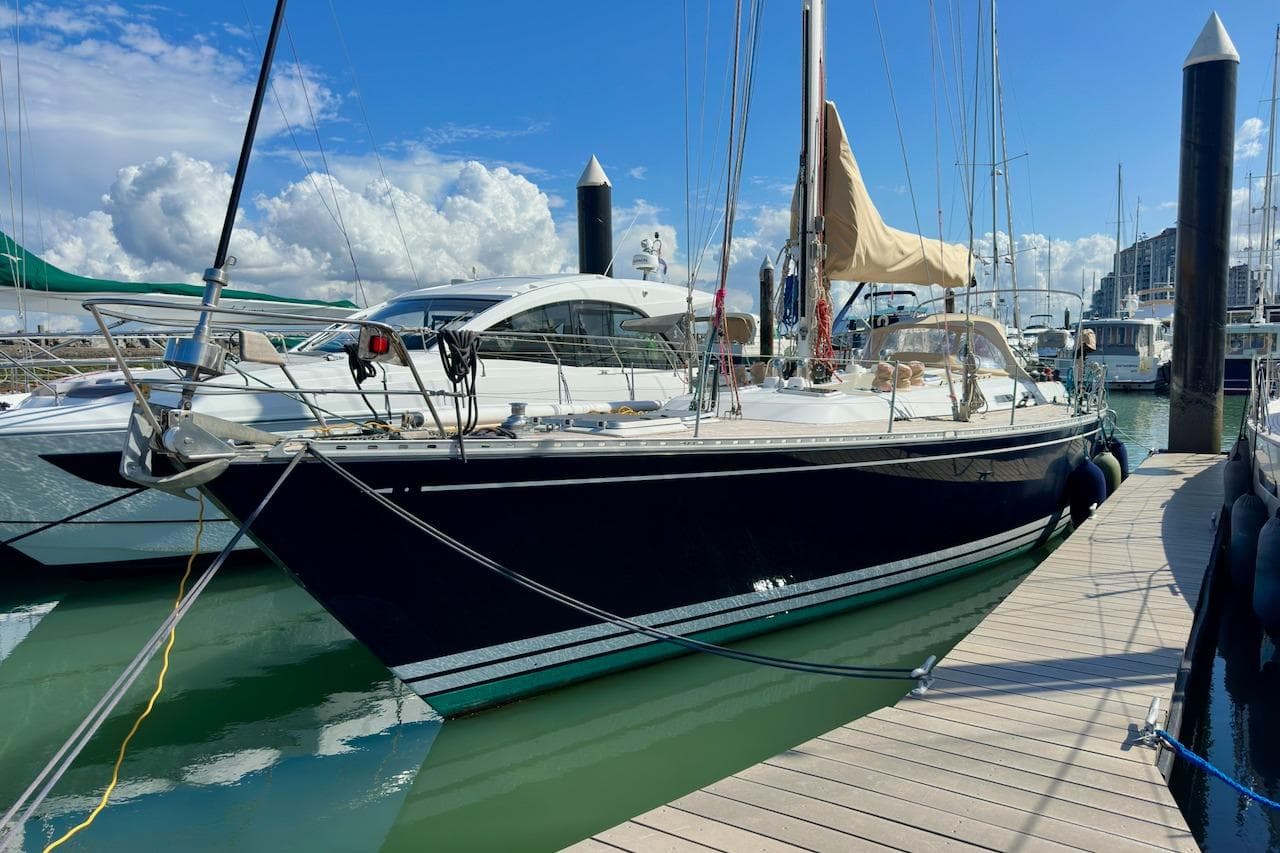 Sailboat docked at marina, Standfast 56 model, 1991, under clear blue sky.