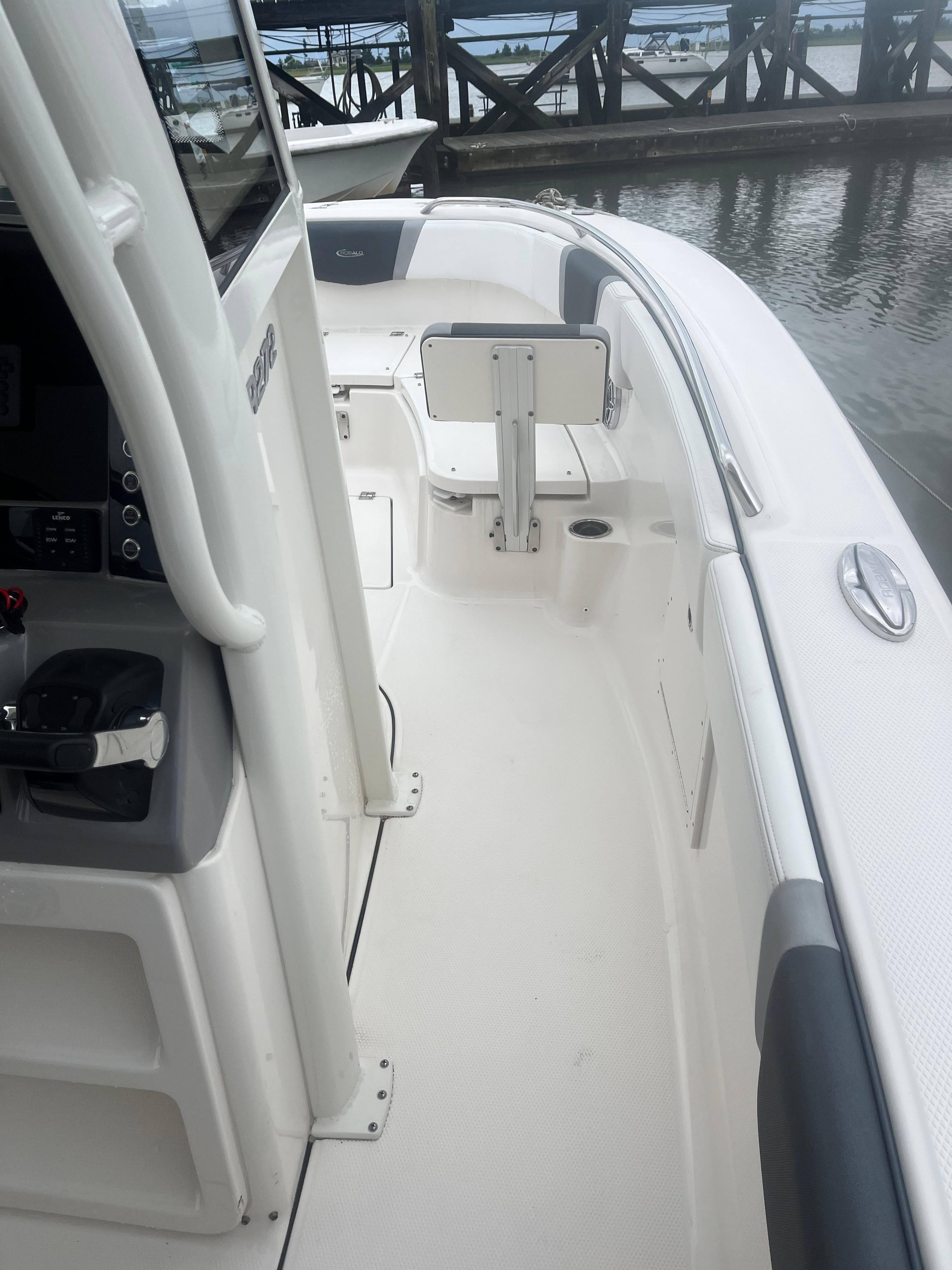 2021 Robalo R272 Center Console boat interior, featuring helm and seating, docked by the water.