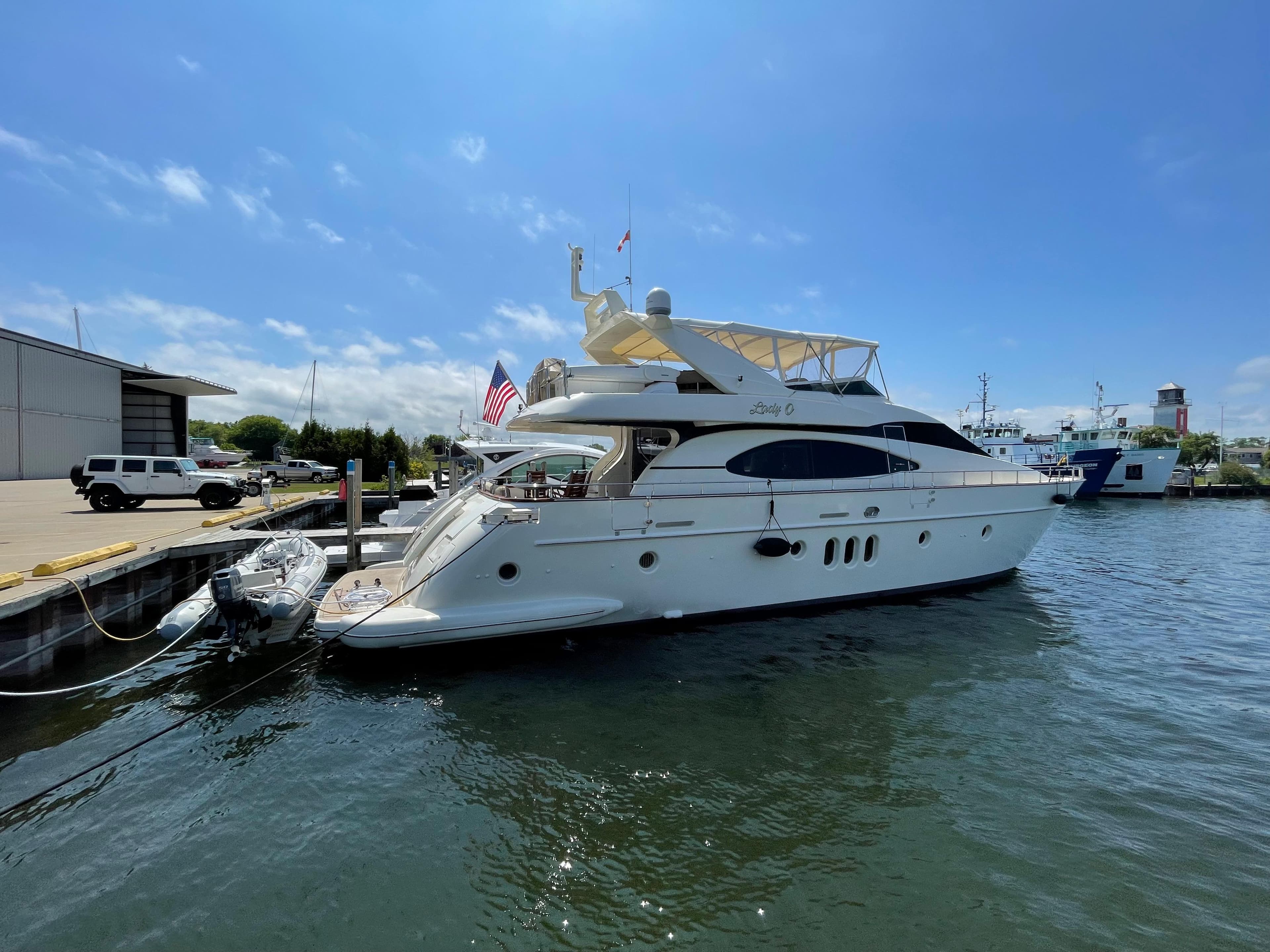 2004 Azimut 74 yacht docked at marina under clear blue sky.