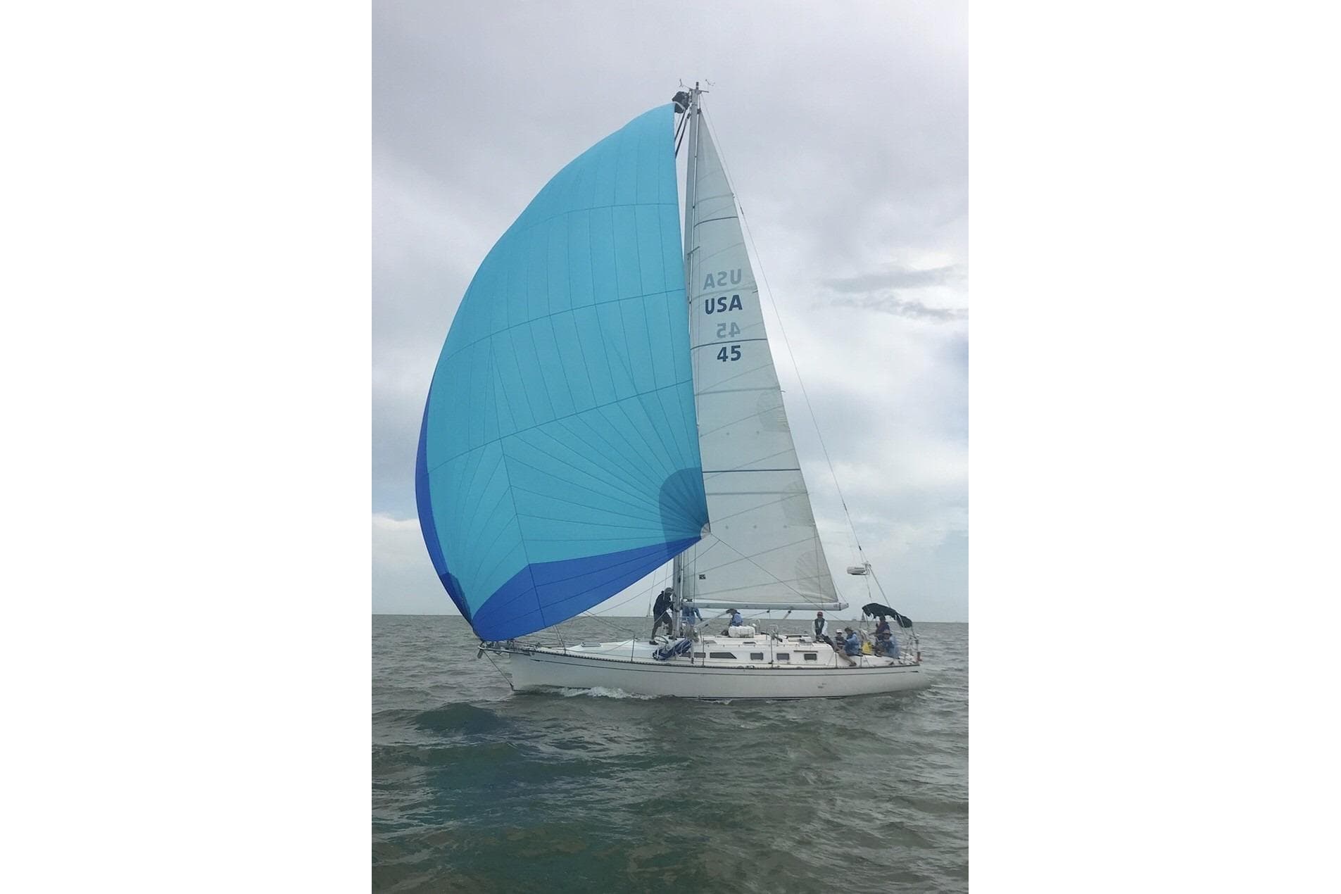 Sailing yacht Saga 43 (2002) with blue spinnaker on open water.