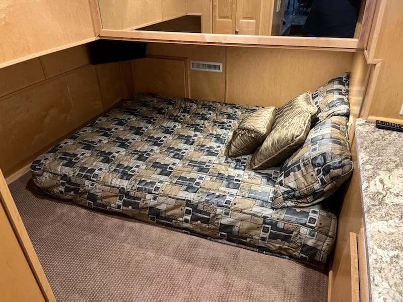 2002 Sumerset Houseboat cozy bedroom with patterned bedding and pillows.