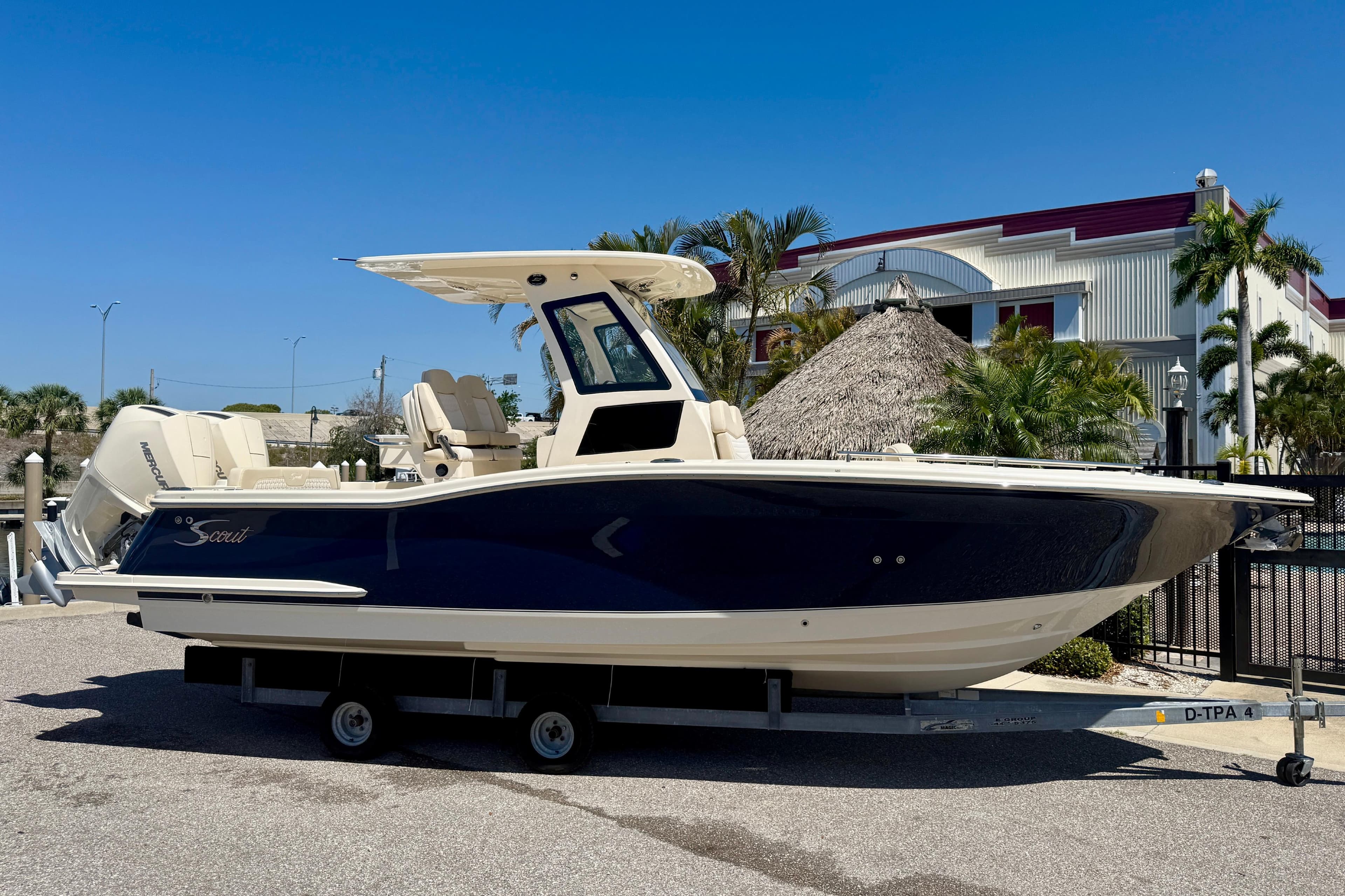 2026 Scout 260 LXF boat on trailer, parked outdoors under clear blue sky.