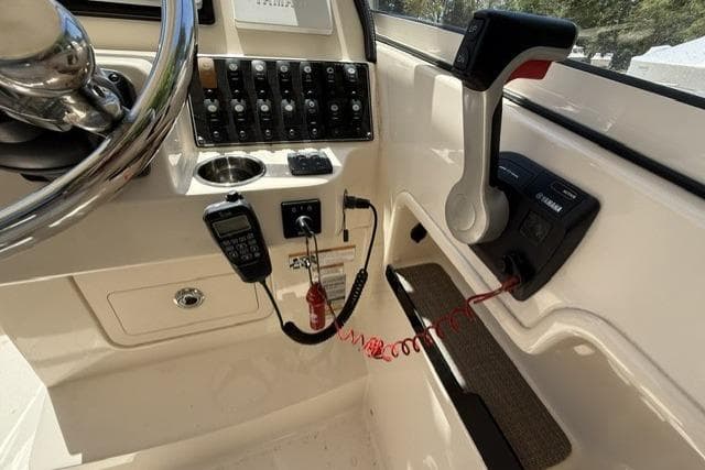 Control panel of 2017 Grady-White Freedom 235 boat with steering wheel and throttle.