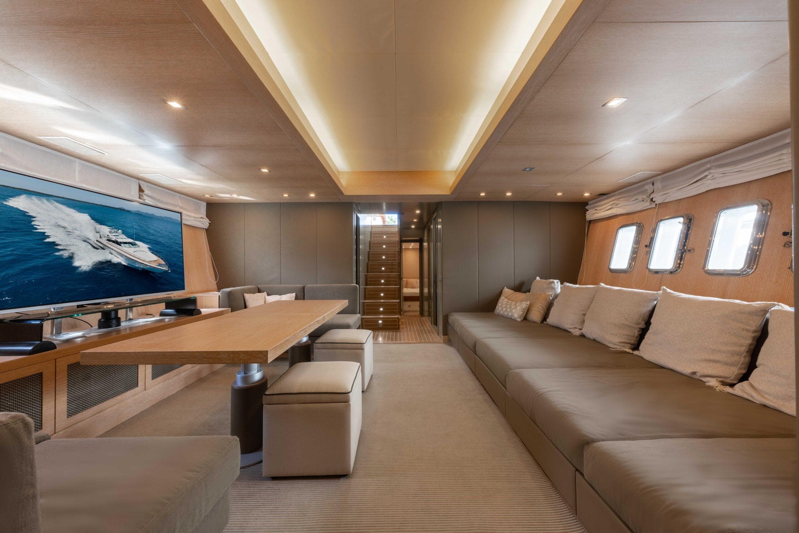 Luxurious interior of 2006 Mangusta 80 yacht with spacious seating and large TV screen.