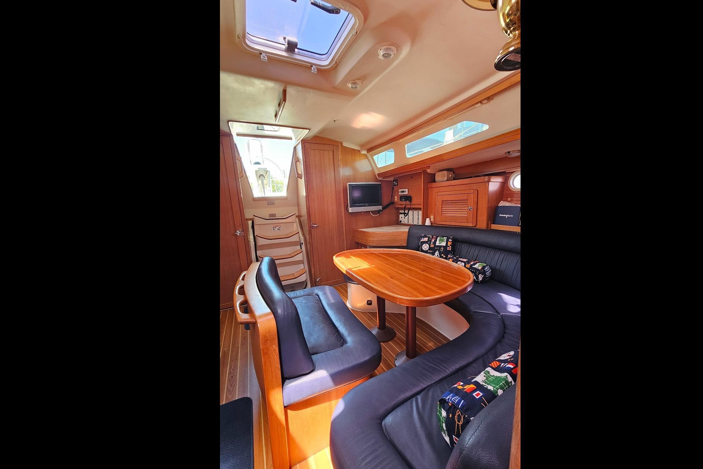 Interior of 2006 Catalina 42 MkII sailboat with cozy seating and wooden table.