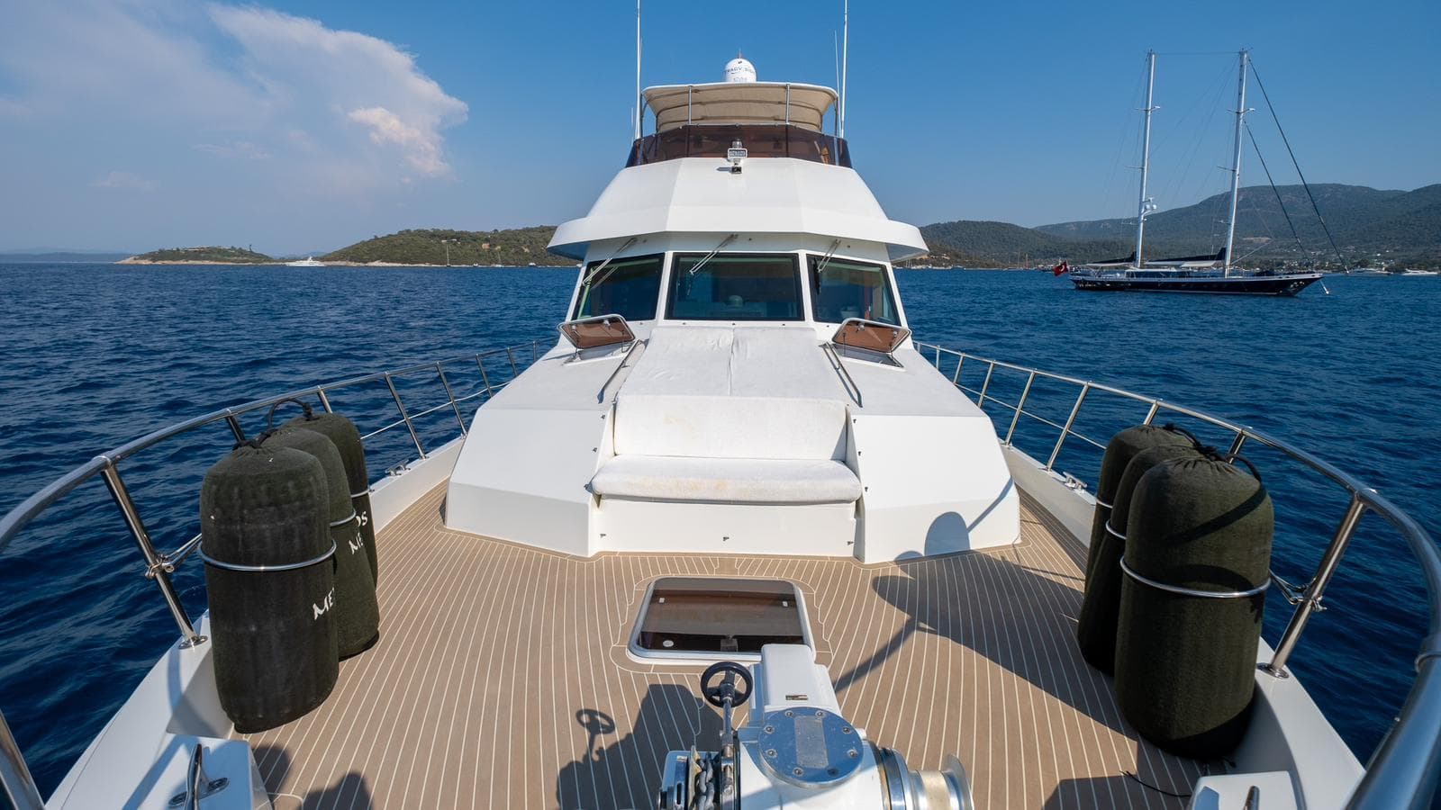 1997 Hatteras 70 yacht on open water, featuring spacious deck and scenic ocean view.