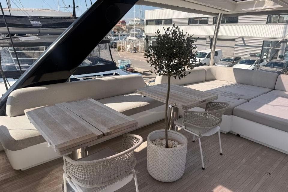 Luxurious 2018 Lagoon SEVENTY 7 yacht deck with seating, tables, and potted plant.