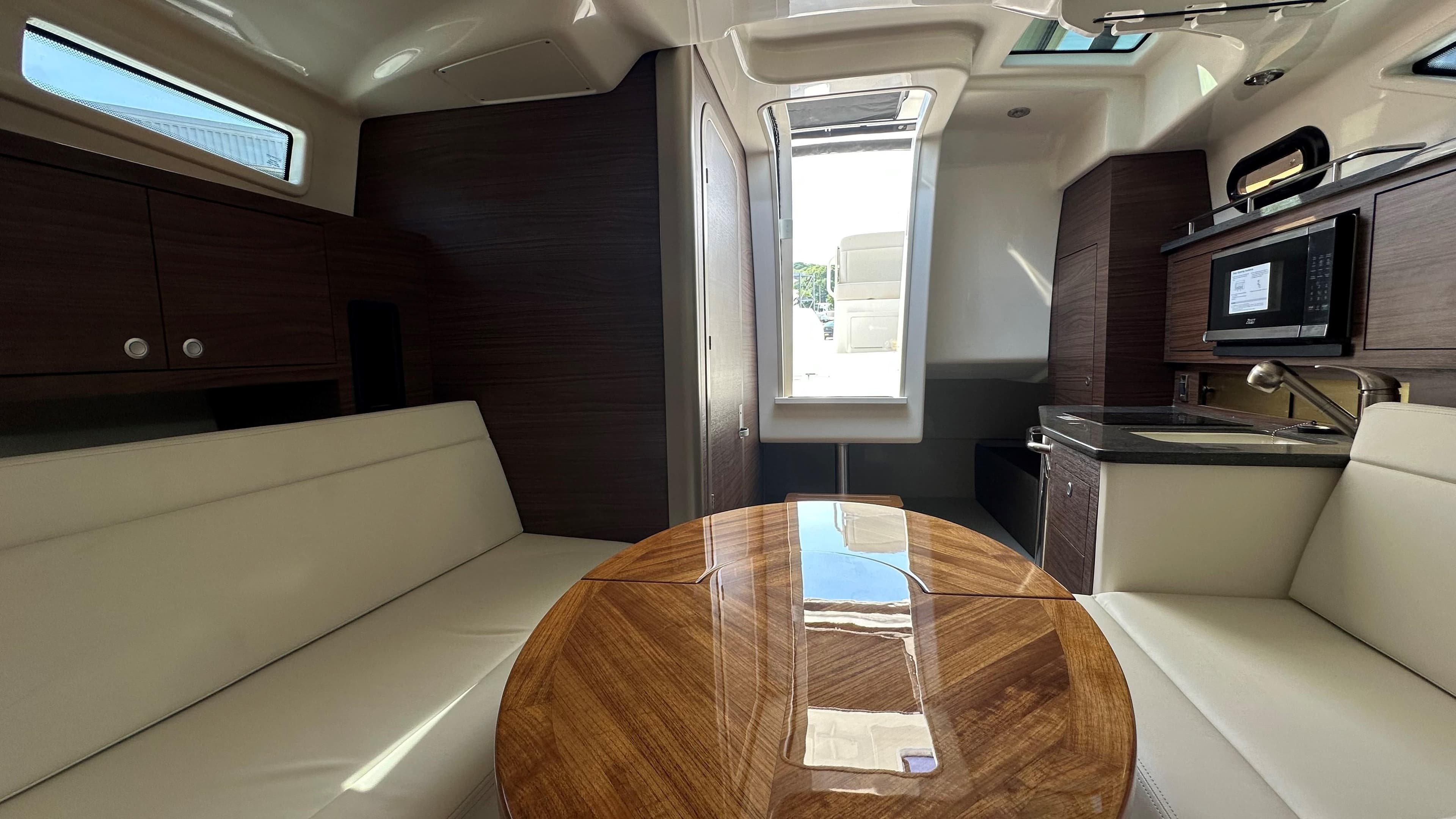 Luxurious interior of 2026 Boston Whaler 325 Conquest with modern kitchen and seating area.