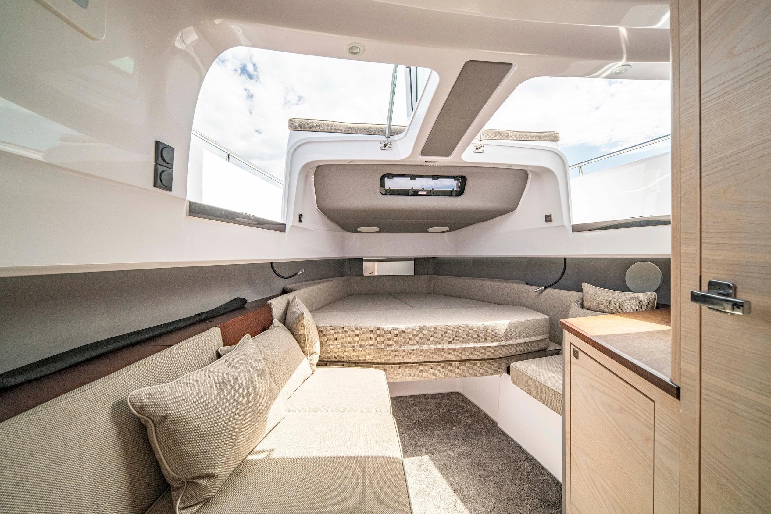 Interior of 2025 Axopar 45 Cross Top boat, featuring cozy seating and modern design.