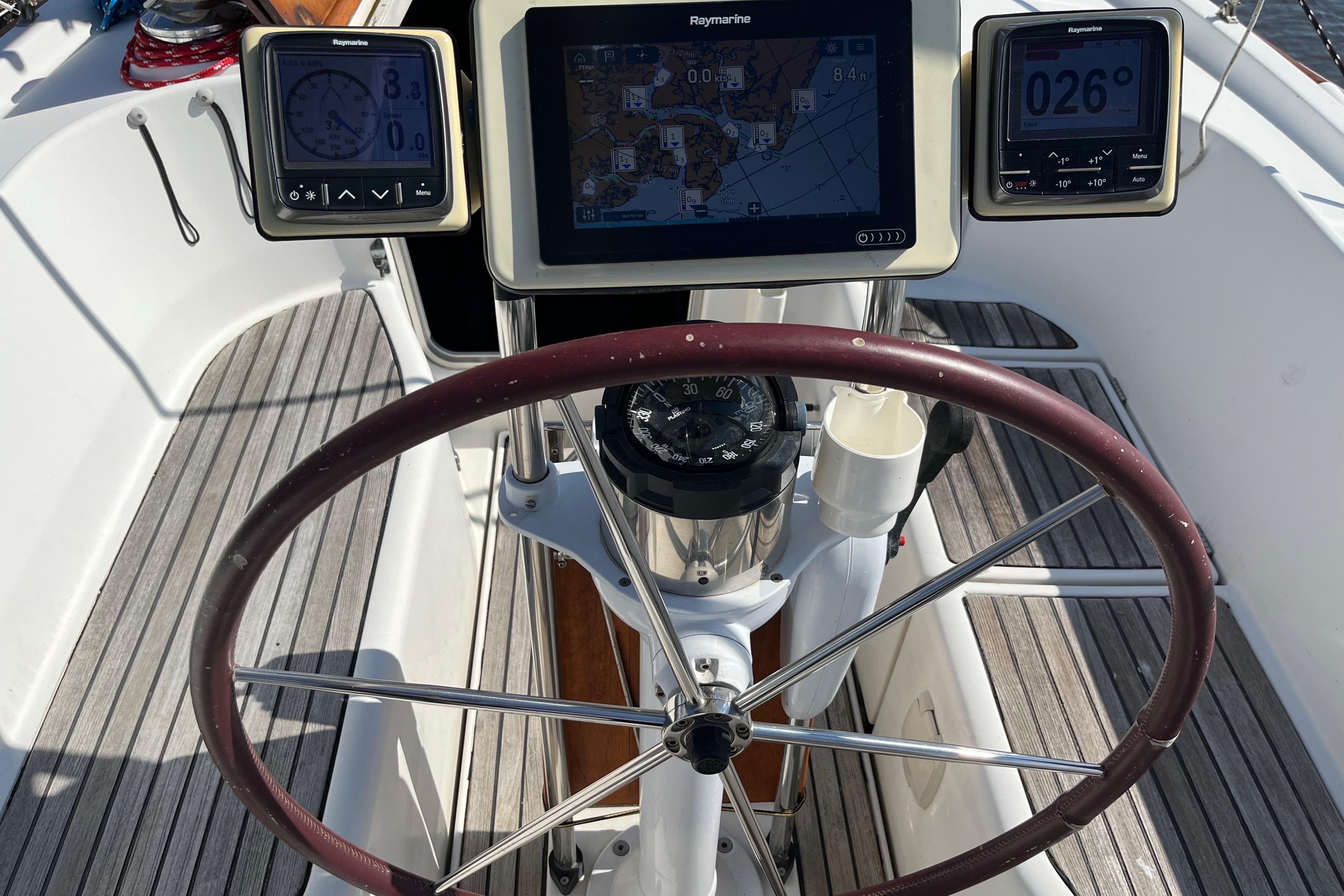 Steering wheel and navigation instruments on a 1997 Beneteau Oceanis 40 CC sailboat.