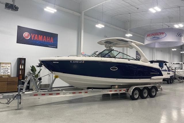 2023 Chaparral 307 SSX boat on trailer in showroom, Yamaha banner above.