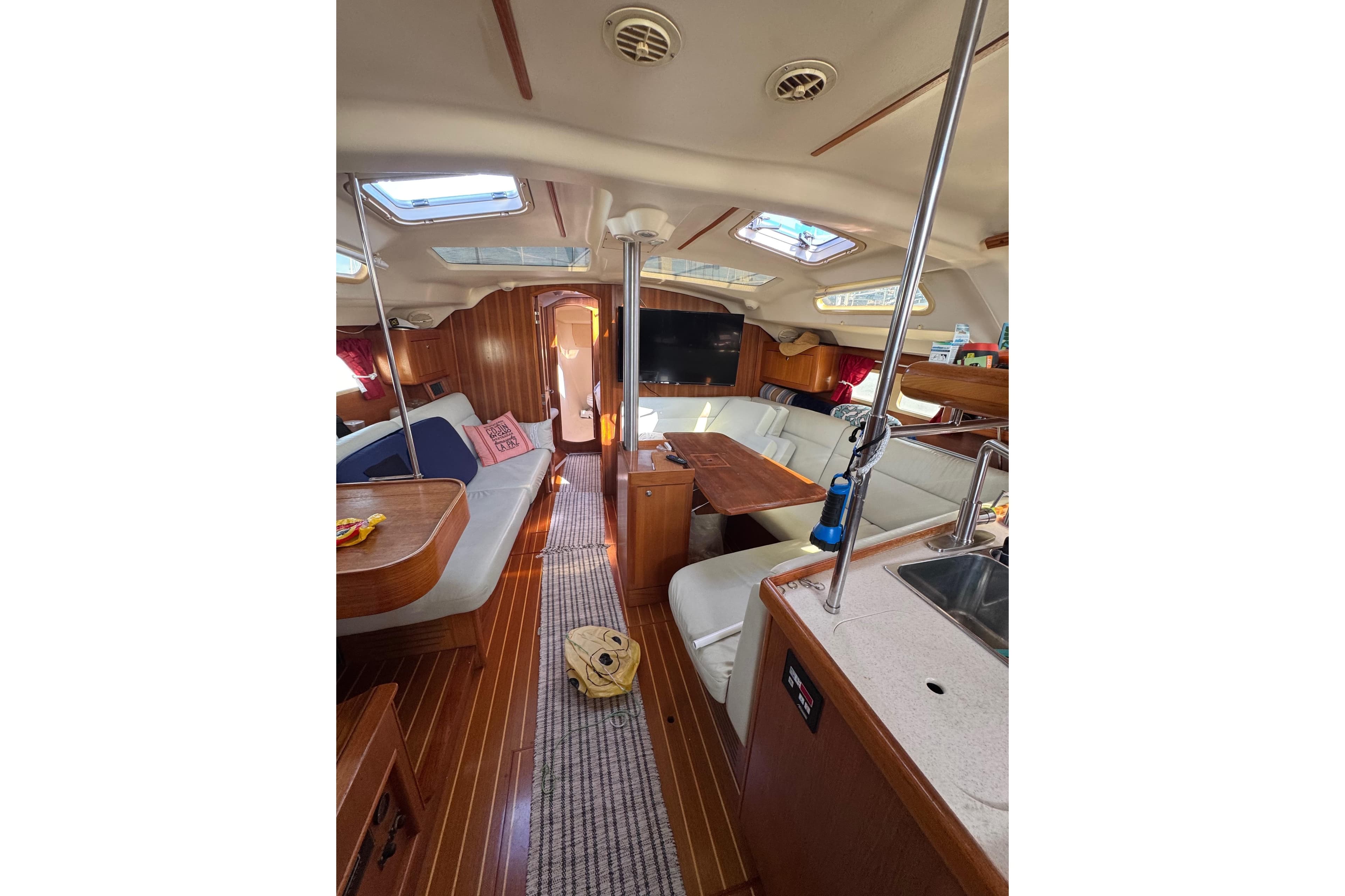 Interior of 2002 Hunter 410 sailboat with cozy seating and wooden finishes.