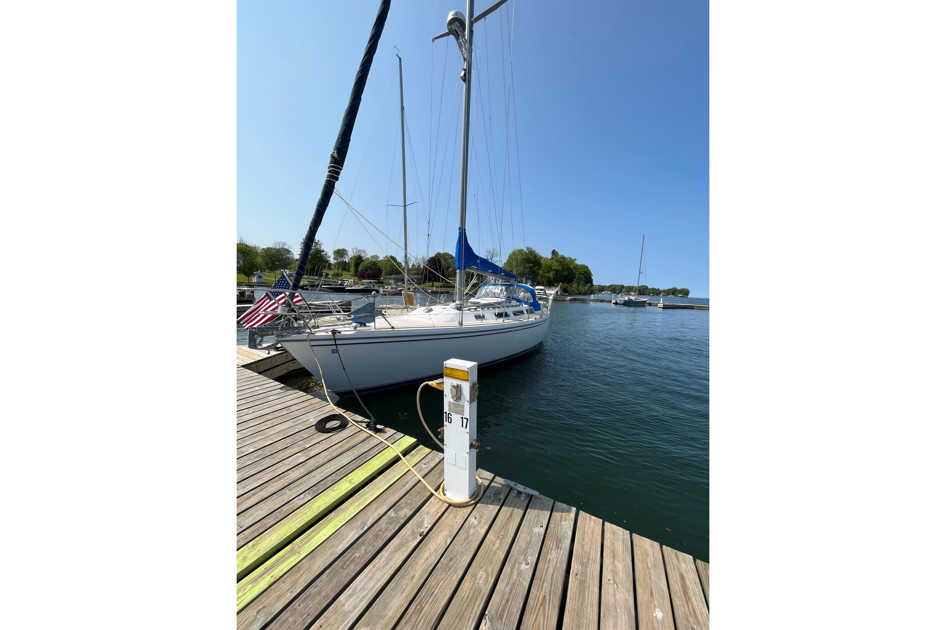 1985 Catalina 36 sailboat docked at a marina on a sunny day.