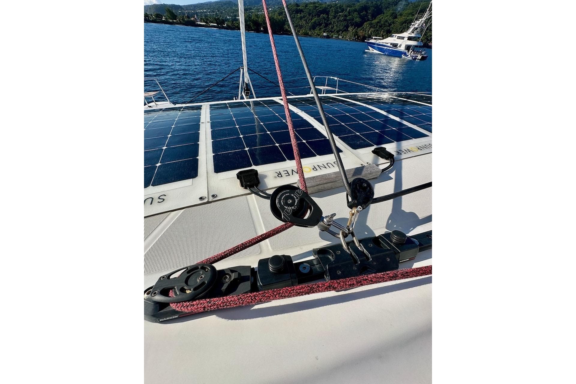2023 Lagoon 46 catamaran with solar panels and rigging, anchored on a serene blue lake.