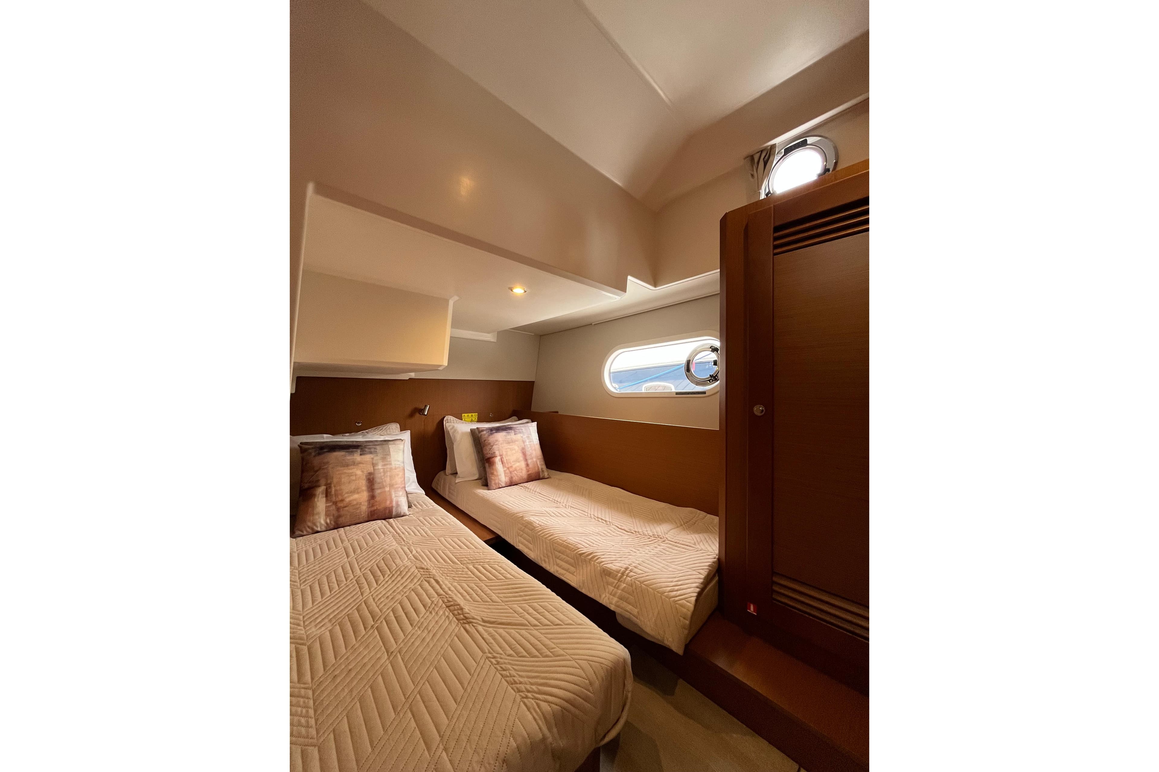 Interior of 2026 Beneteau 41 Swift Trawler Sedan with twin beds and porthole.