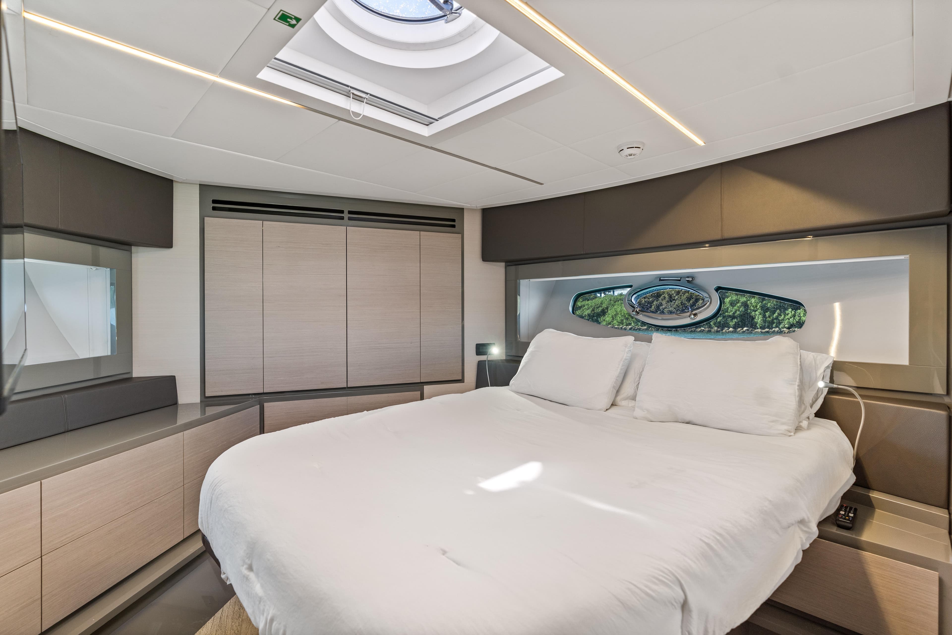 Luxurious bedroom interior of 2016 Pershing 62' yacht with skylight and modern design.