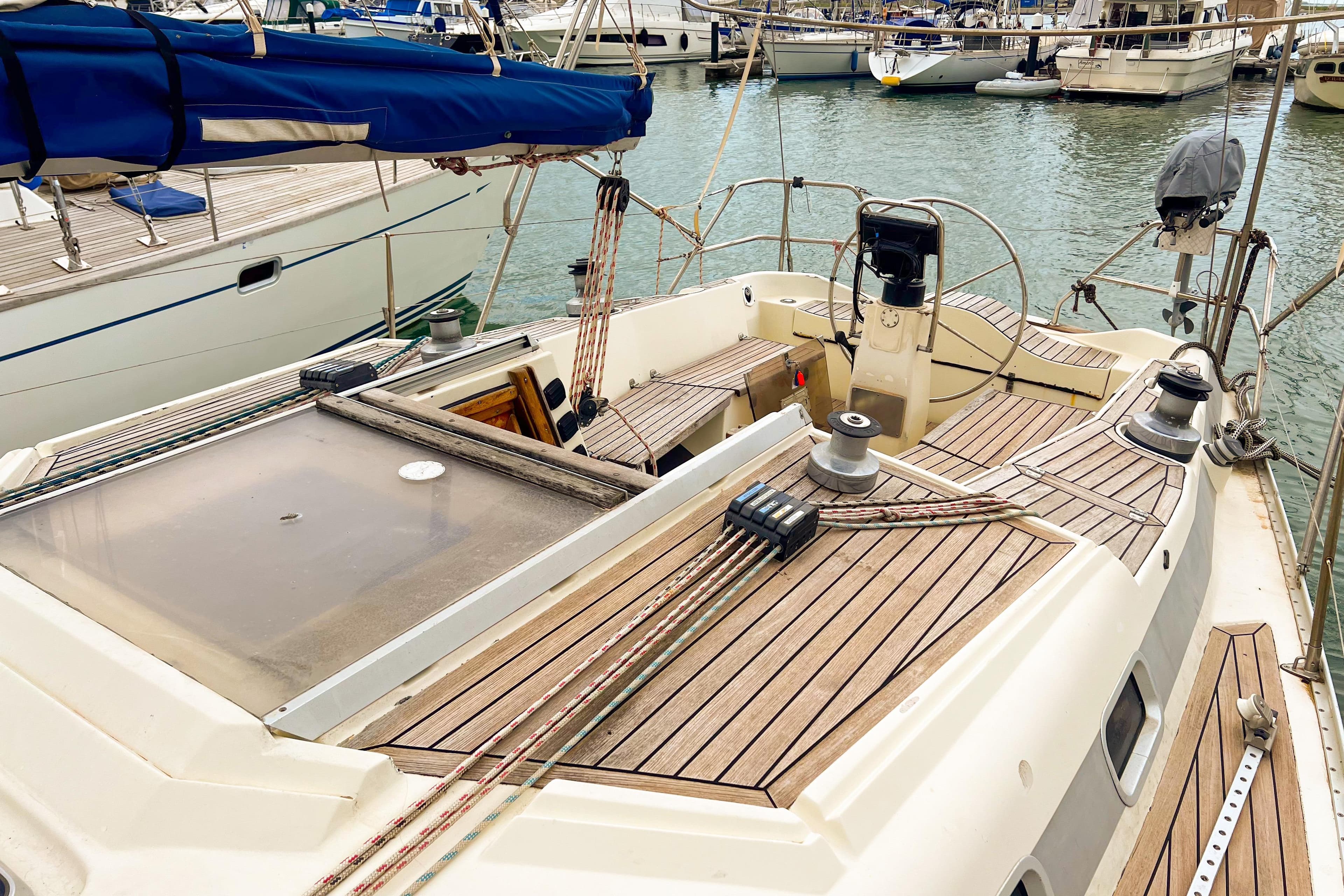 1988 Bavaria 42 Caribic sailboat deck with wooden finish in marina.