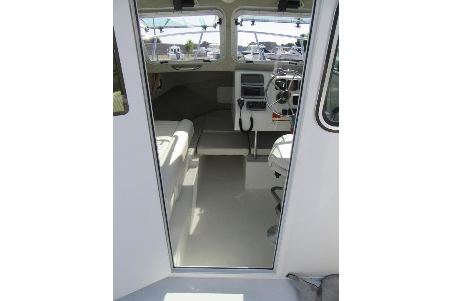 Interior view of 2013 Parker 2320 SL Sport Cabin boat, featuring steering wheel and seating.