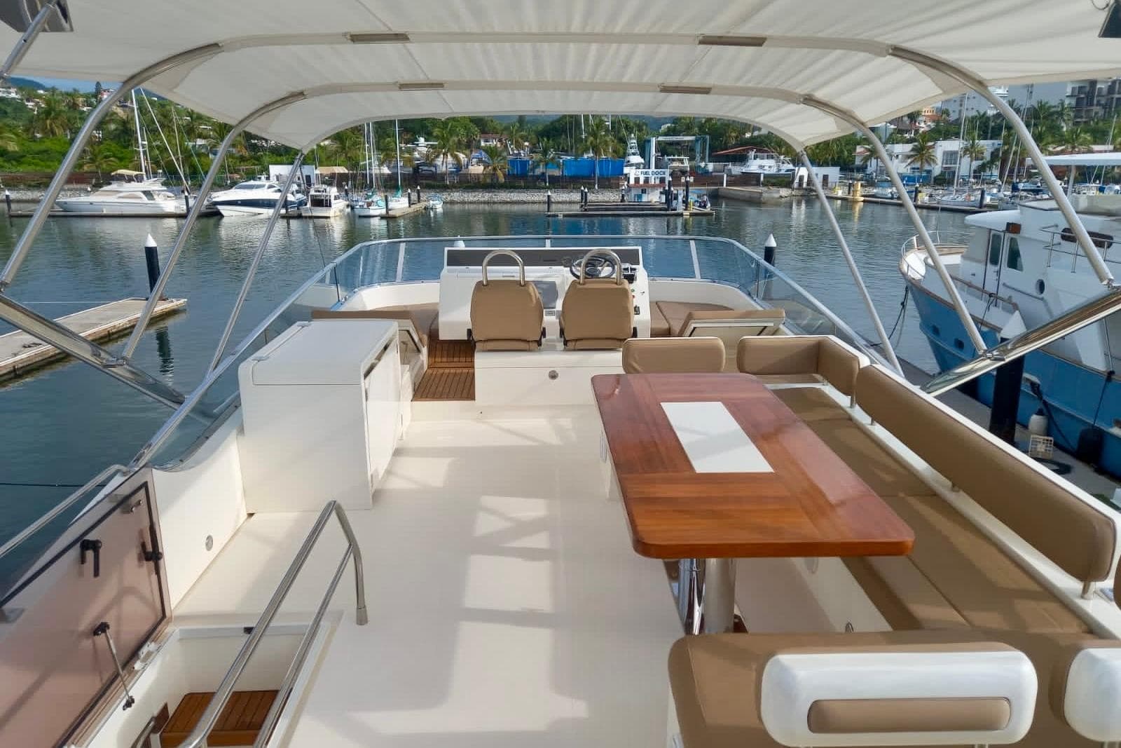 Luxurious 2012 Fairline Squadron 65 yacht interior with seating and dining area in marina.