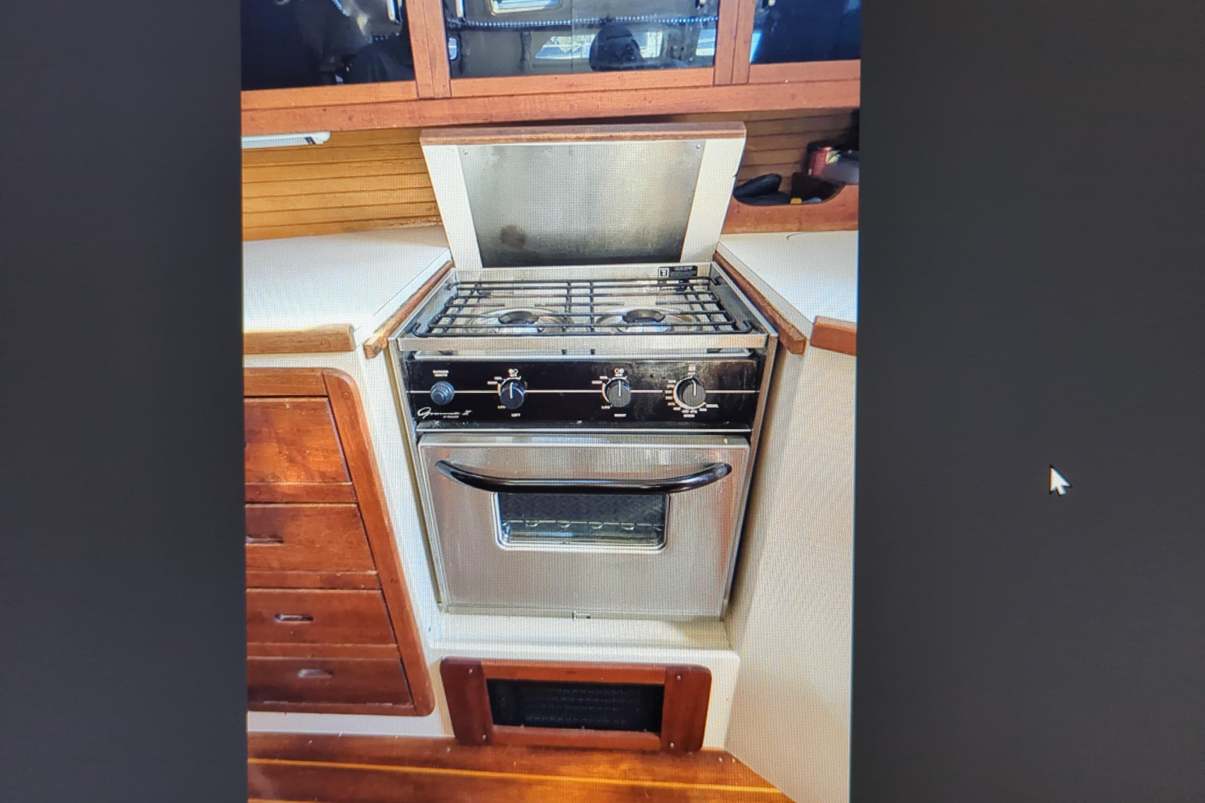Stainless steel stove in 1990 Catalina 42 yacht kitchen with wooden cabinetry.