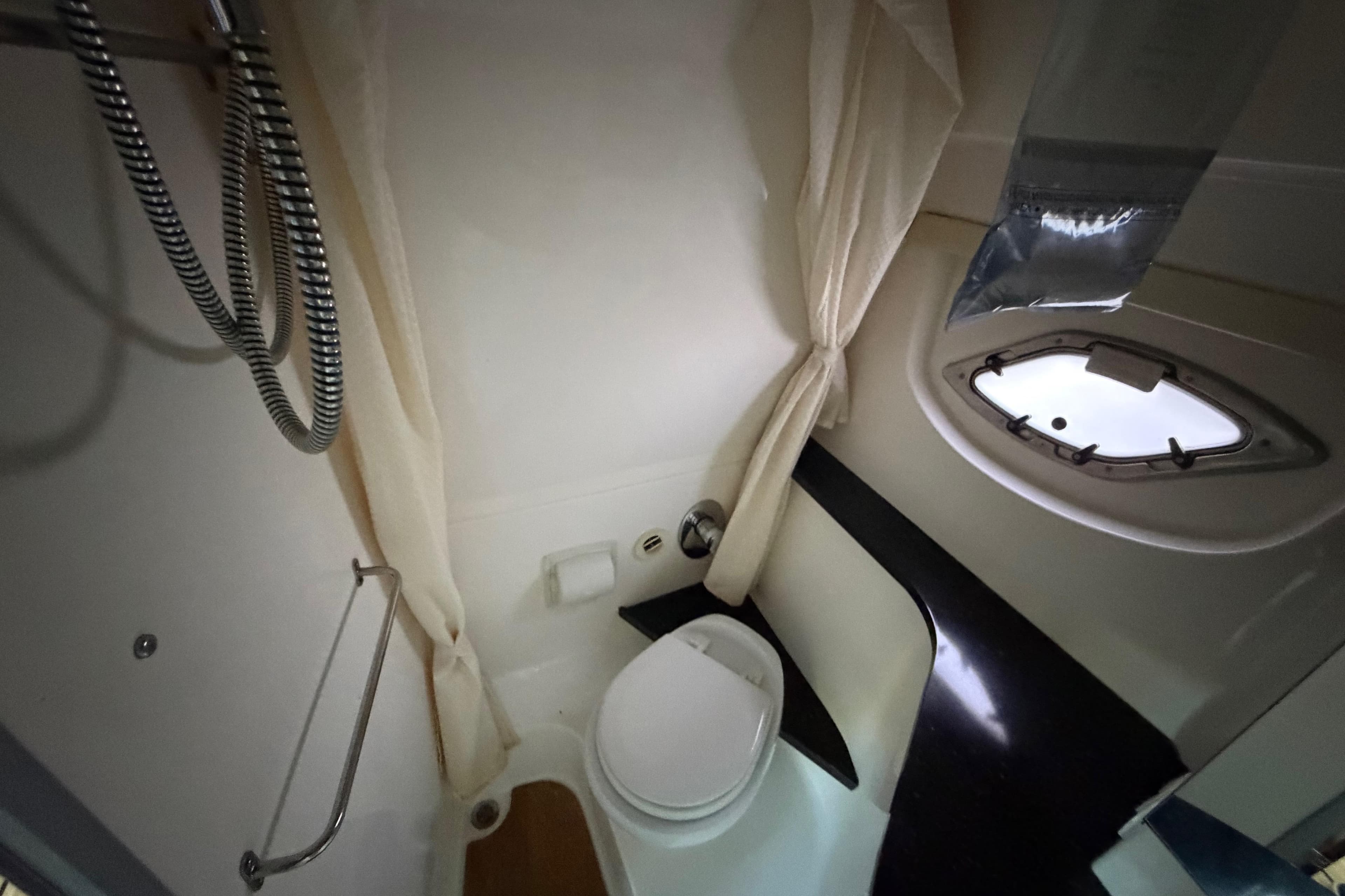 Bathroom interior of 2013 Regal 35 Sport Coupe yacht with shower and porthole window.