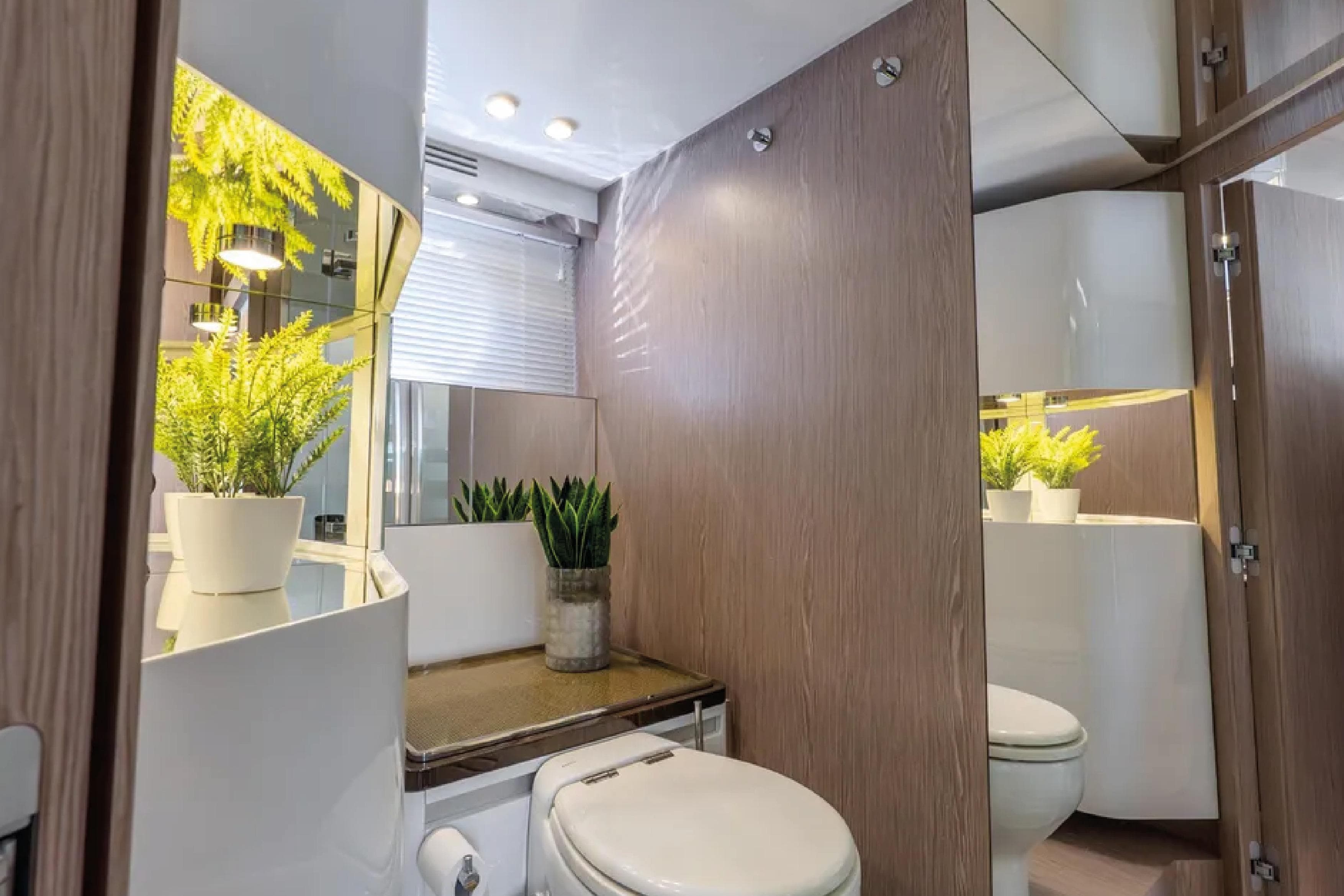Luxurious 2019 Azimut S7 yacht bathroom with modern decor and potted plants.