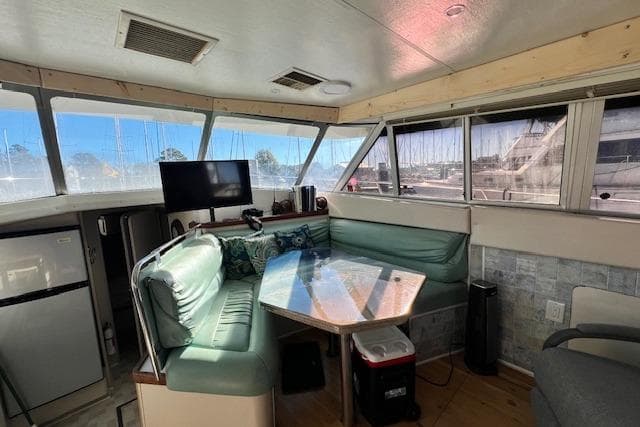 1989 Trojan 12 Meter Motor Yacht interior with seating, table, and windows.