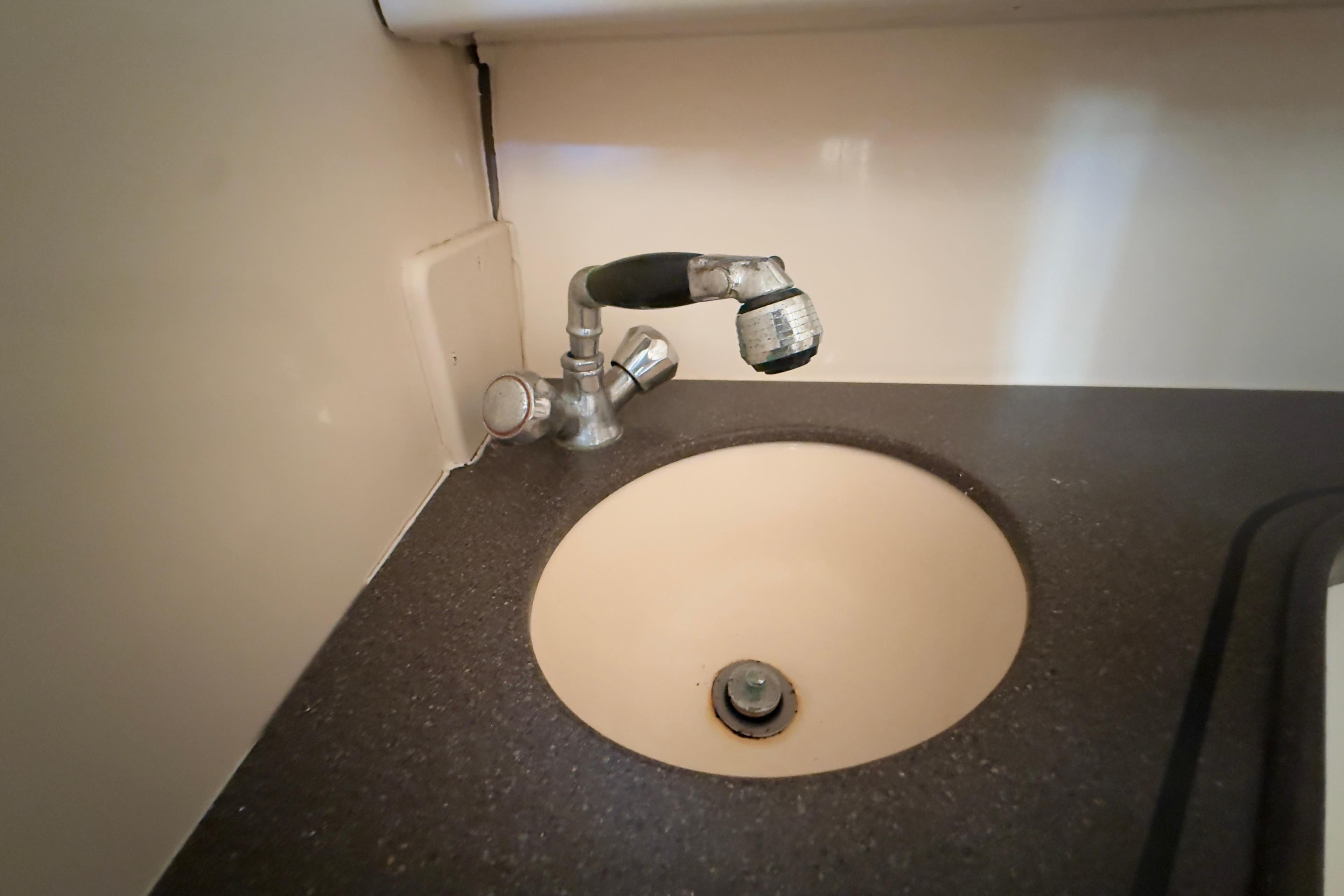 2005 Grady-White Express 330 boat sink with faucet in cabin interior.