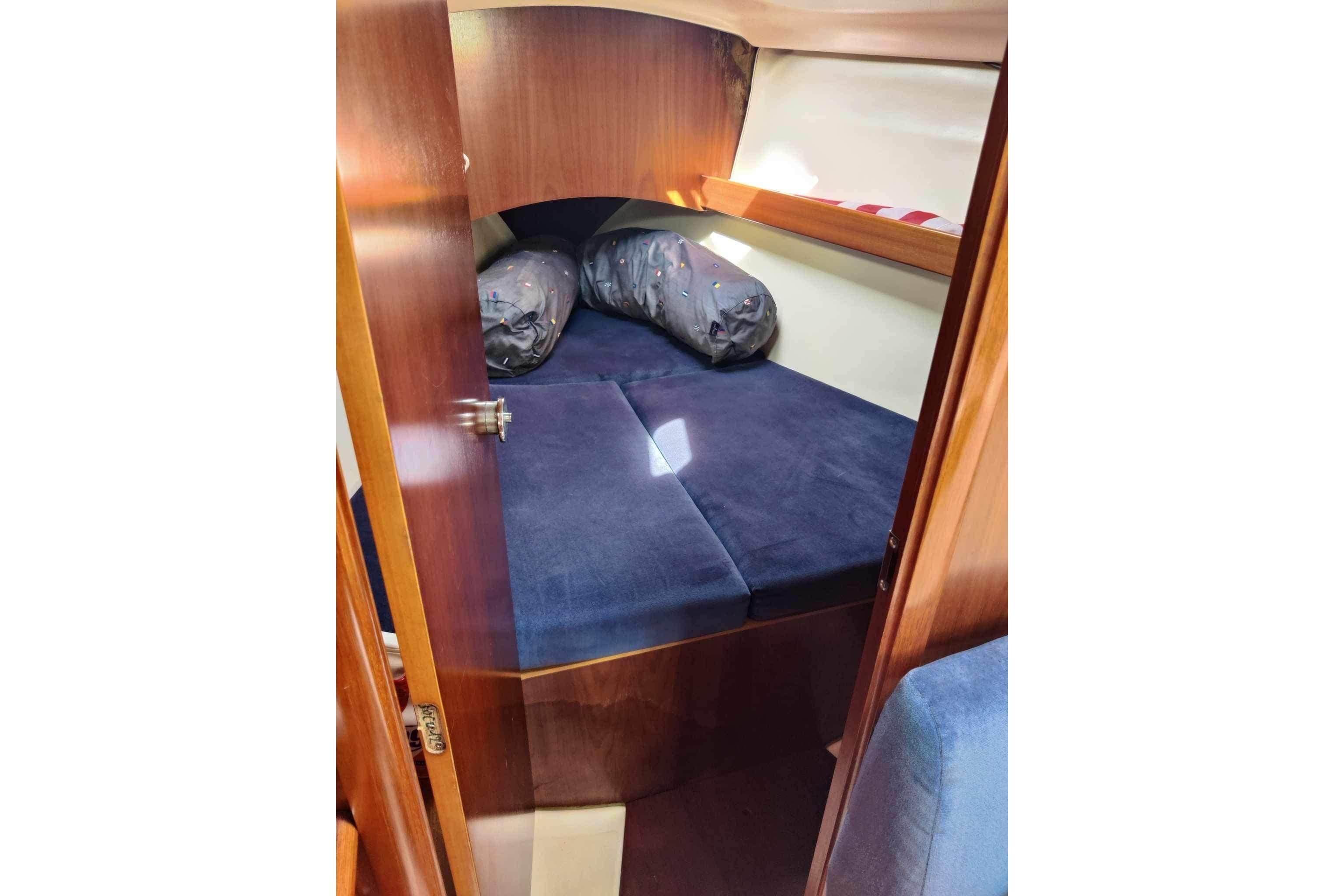 Cozy cabin interior of 1998 Beneteau Oceanis 352 sailboat with blue bedding.