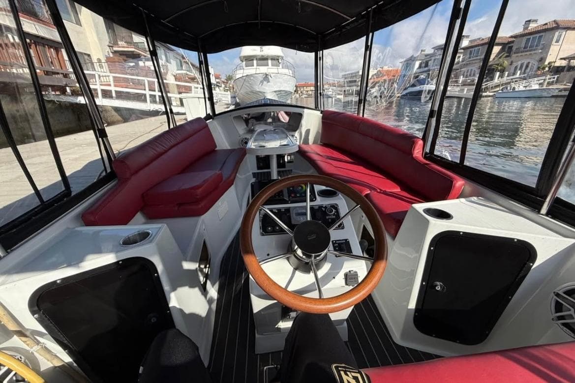 Interior view of a 2001 Duffy Classic 21 boat with red seating and wooden steering wheel.