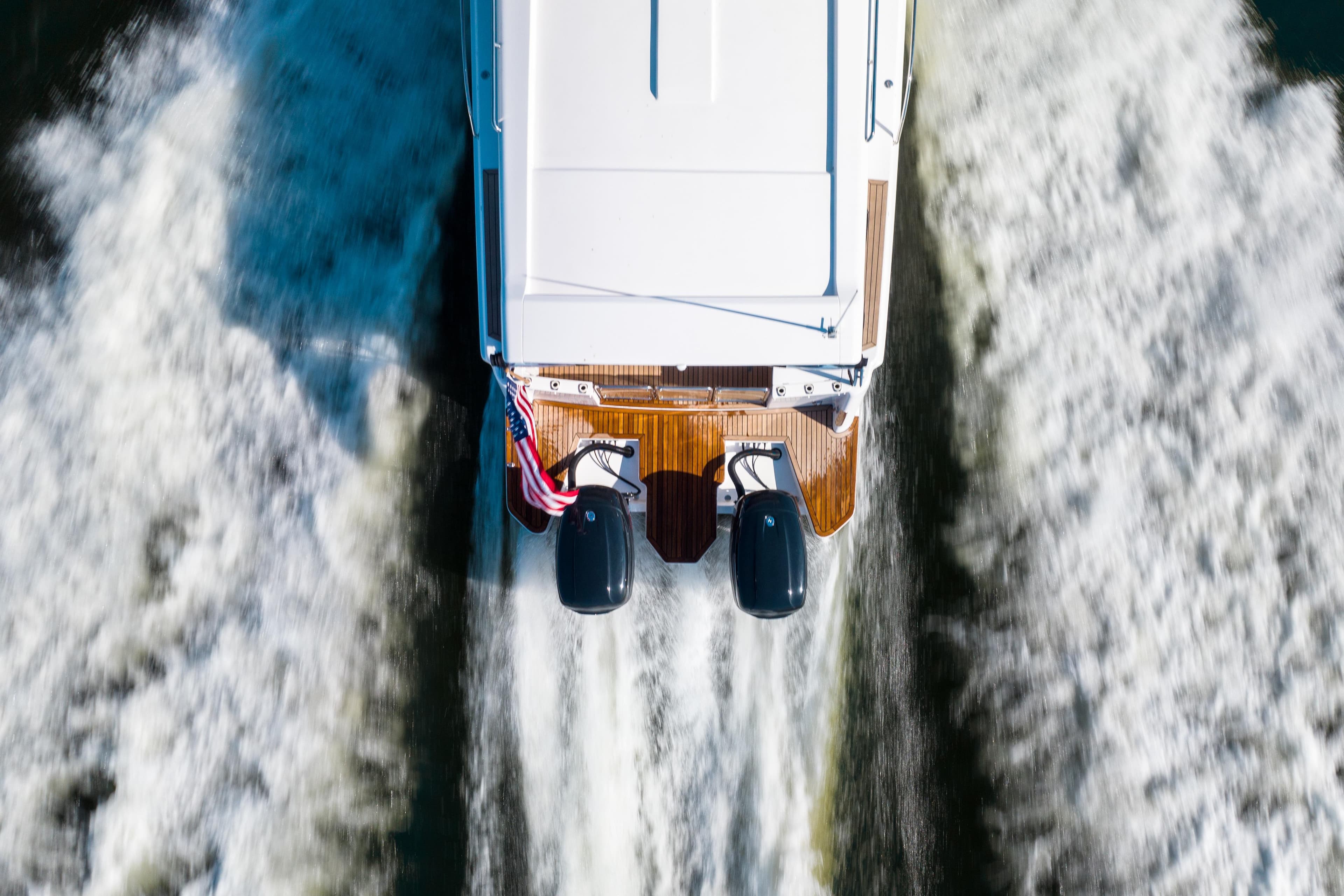 Aerial view of 2025 Hylas M49 boat cruising with twin engines and American flag.