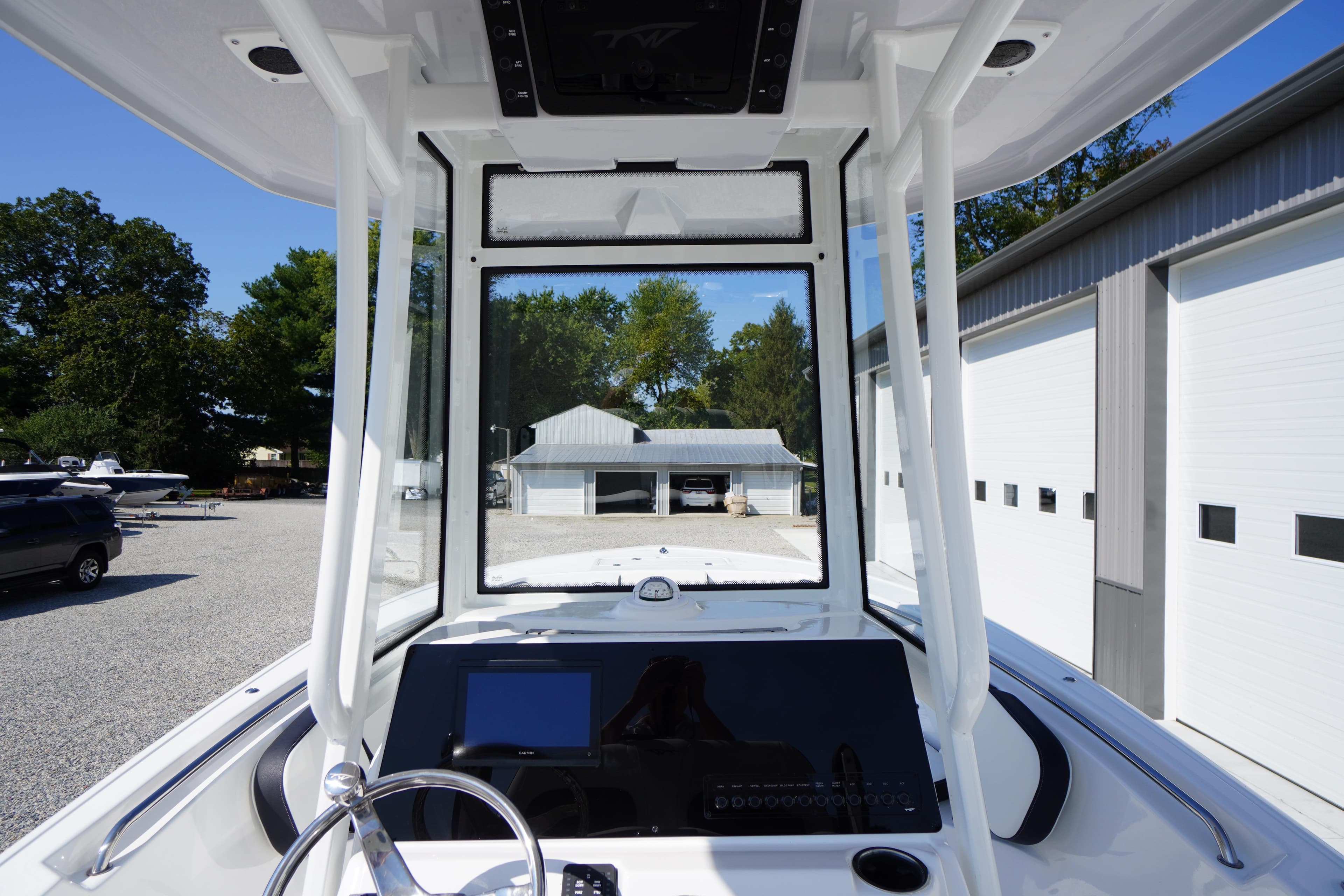 2026 Tidewater 220 LXF boat dashboard with steering wheel and navigation screen.