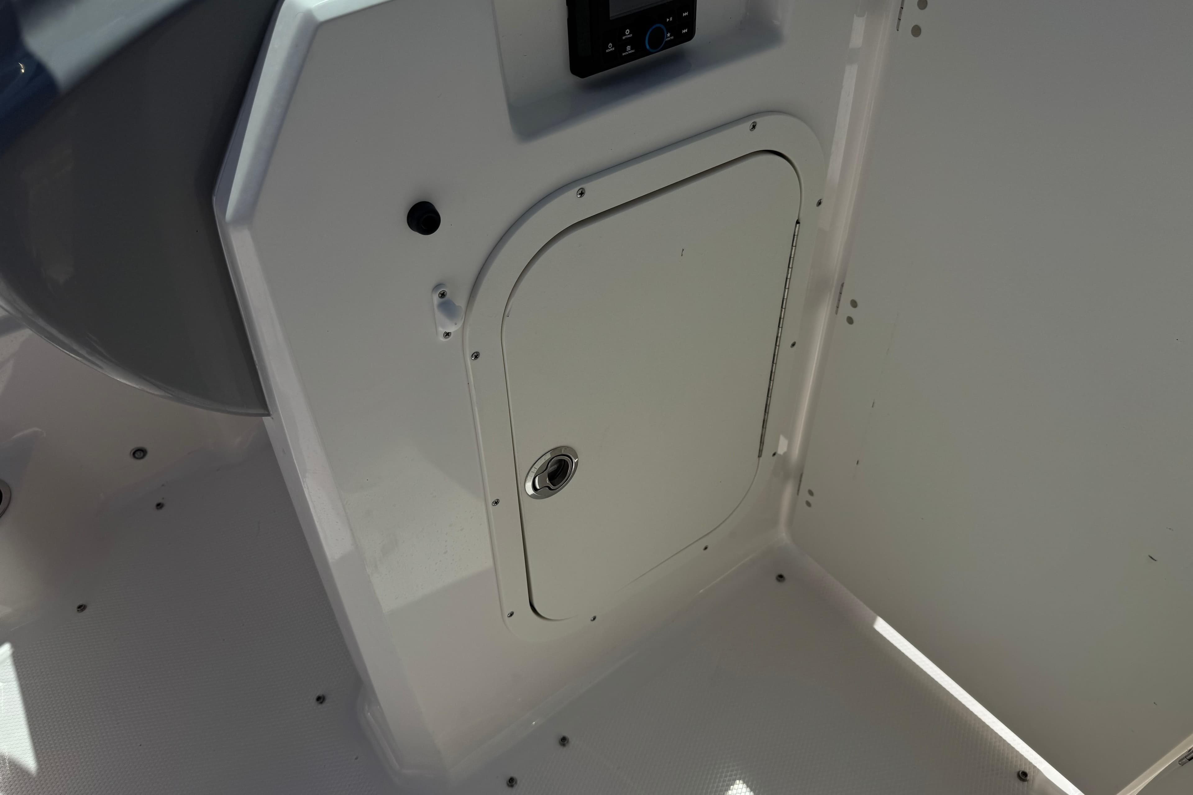 2023 Chaparral 23 SSi boat interior storage compartment with control panel.