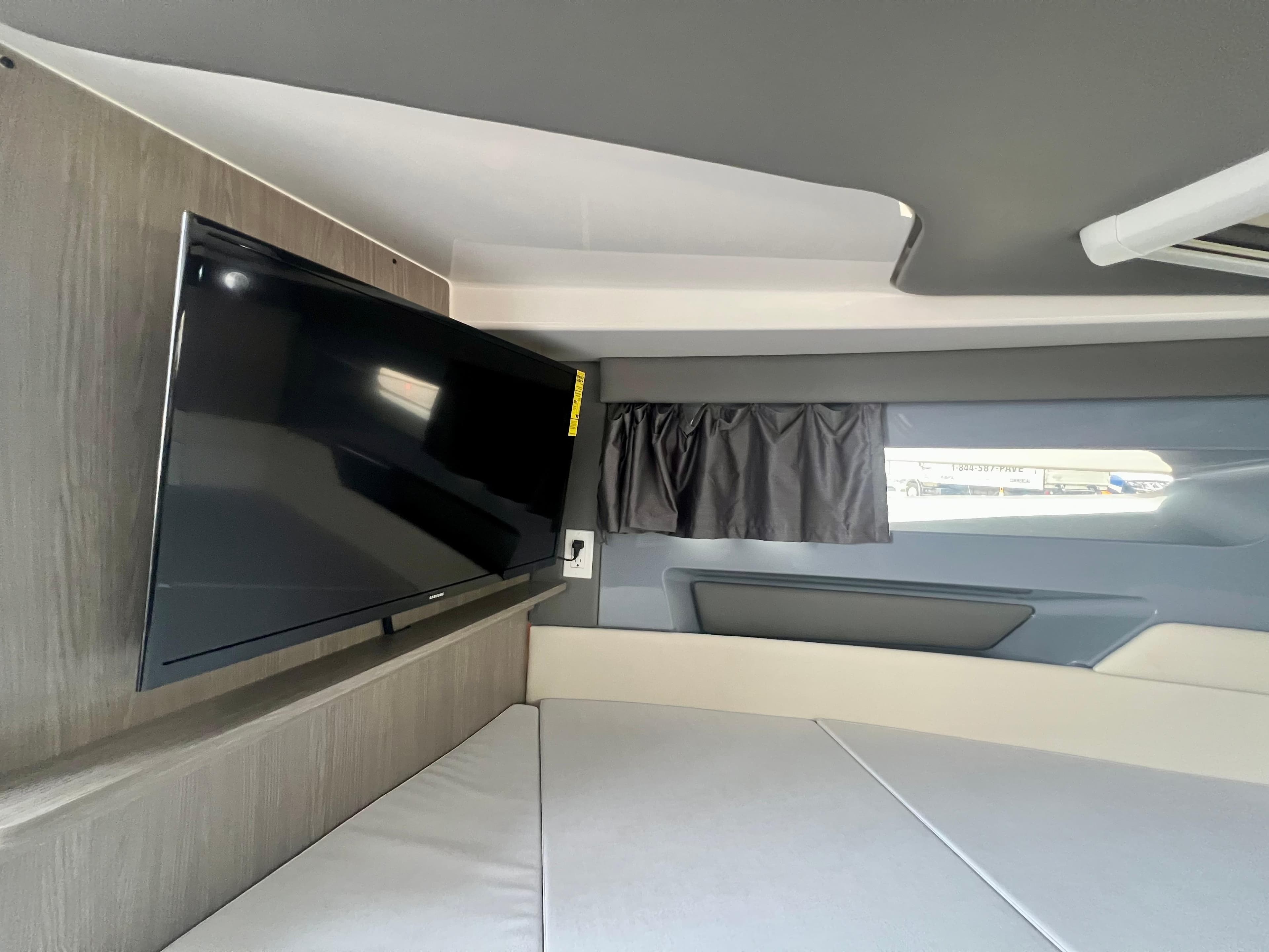 Interior of 2025 Navan S-30 with TV, modern design, and comfortable seating.