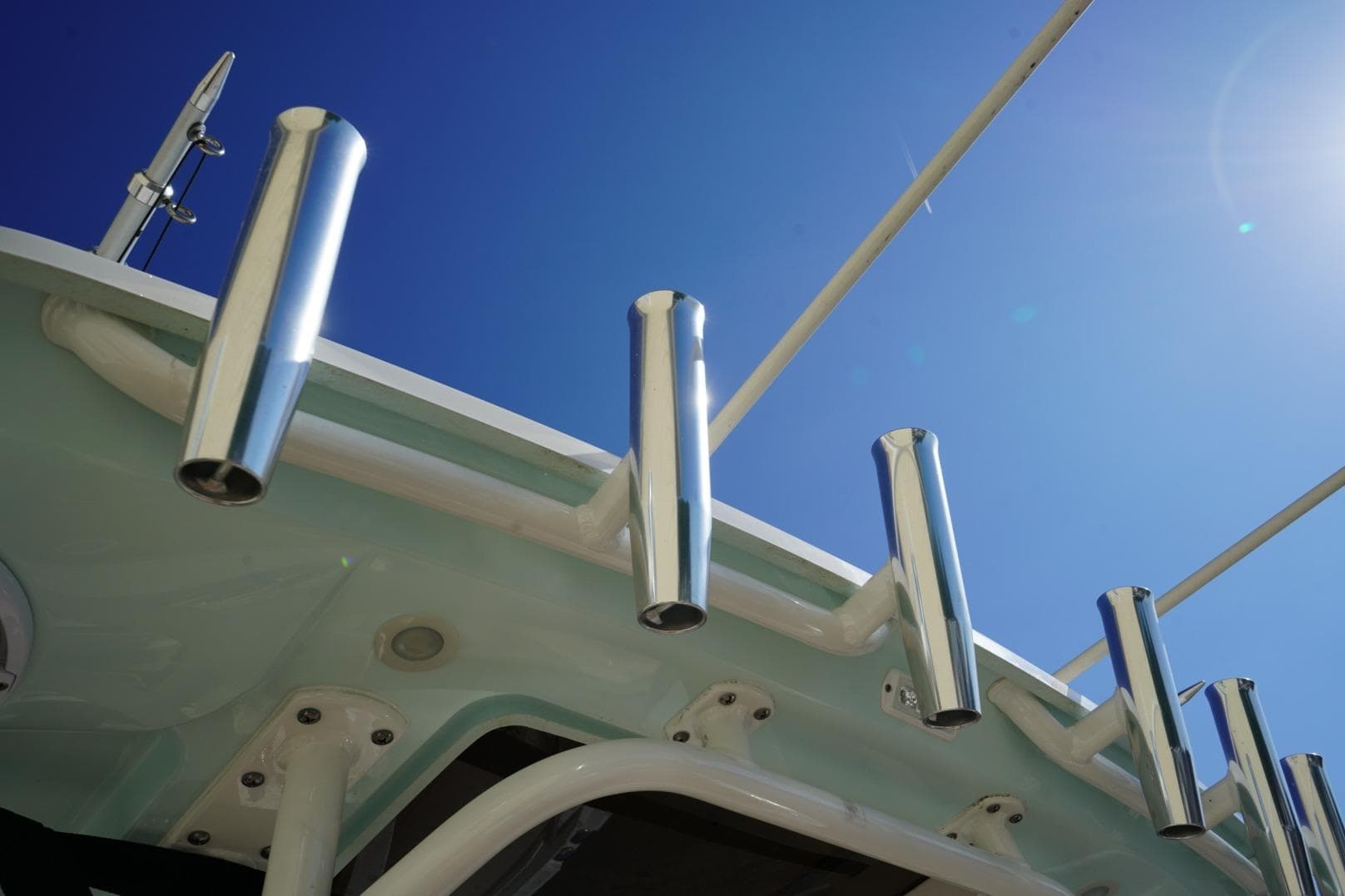 2024 Edgewater 285CC boat rod holders against clear blue sky.