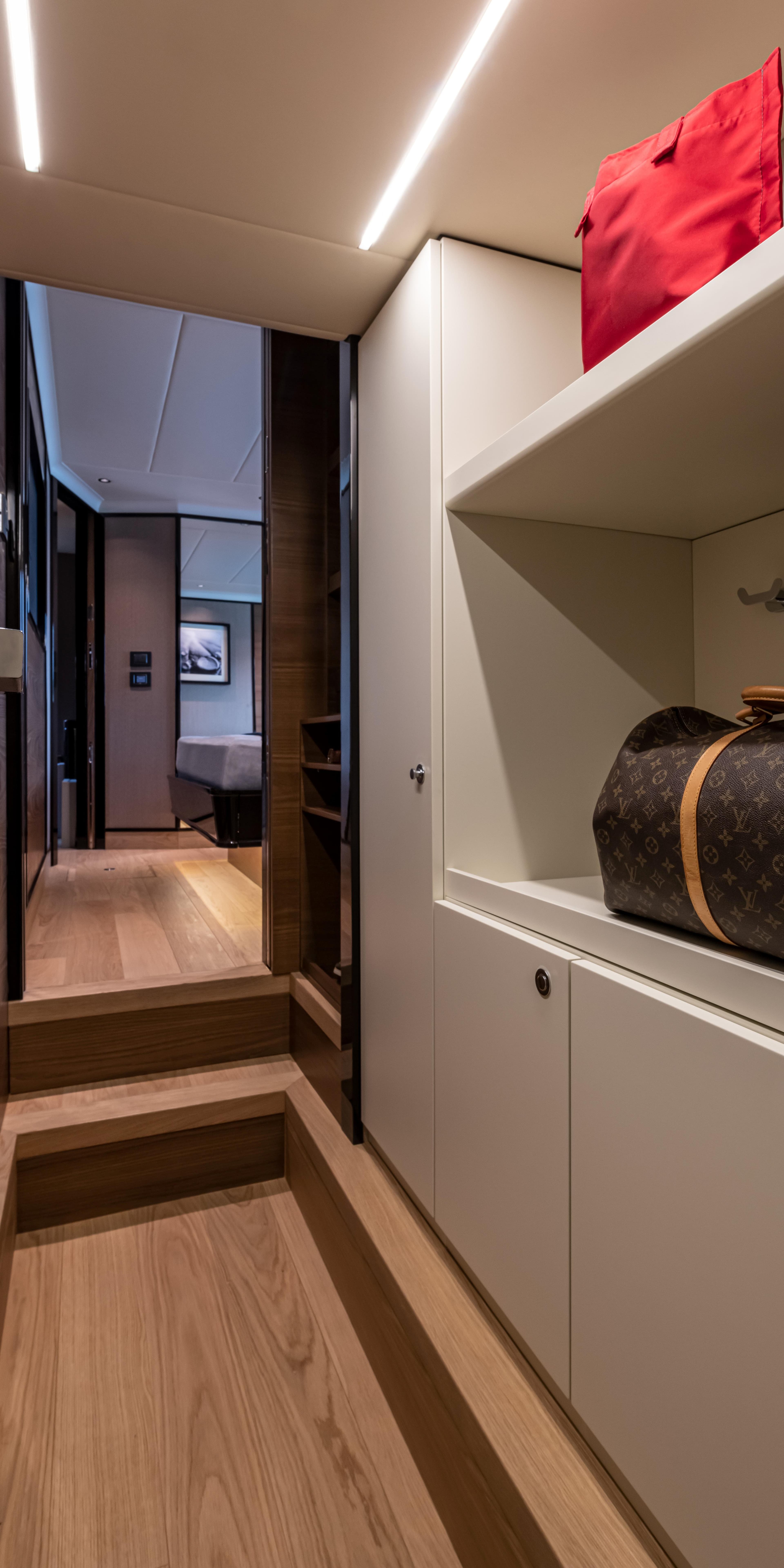 Luxurious interior of 2025 Absolute NAVETTA 75 yacht with modern design and elegant storage.