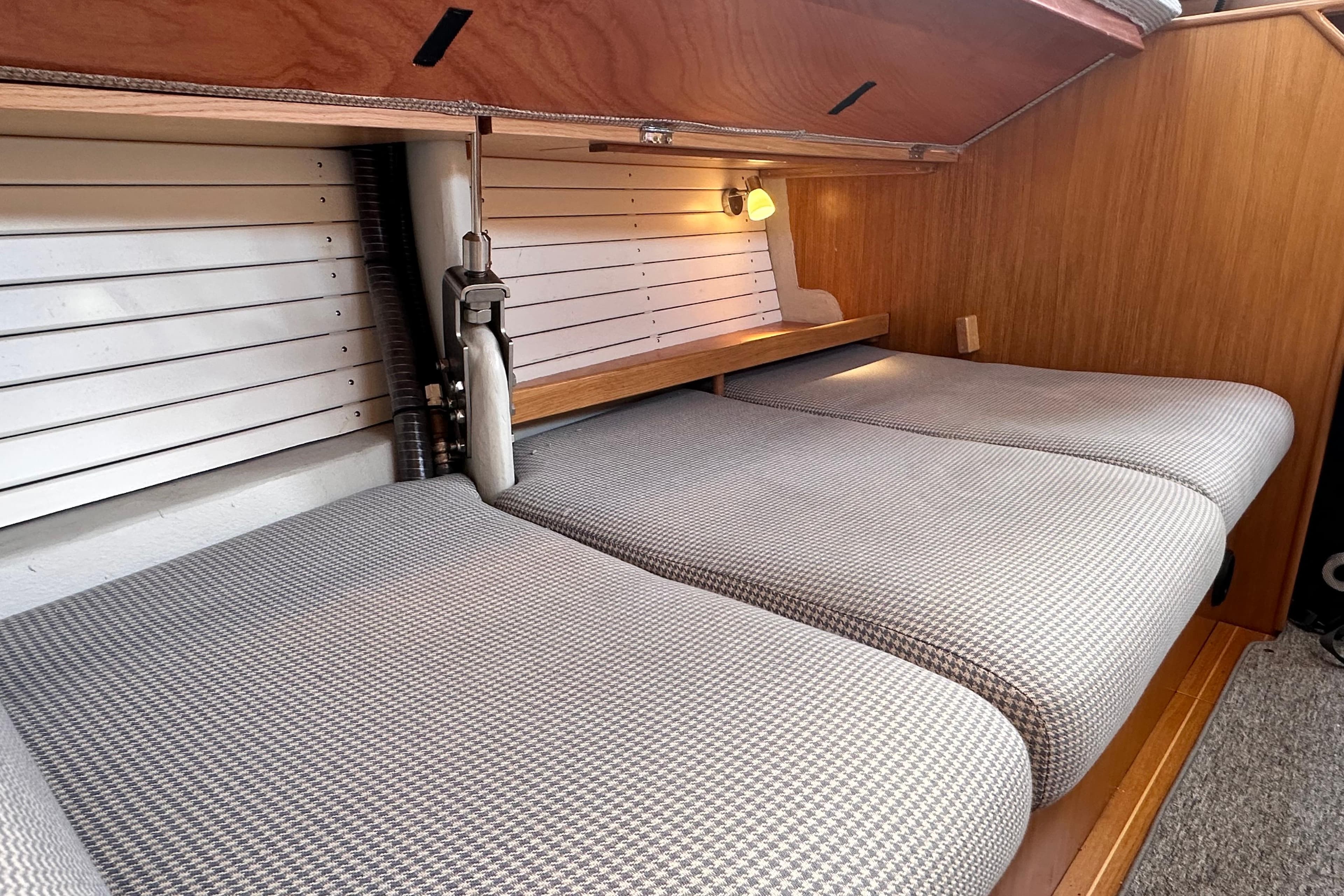 Cozy cabin interior of 2019 Hallberg-Rassy 44 yacht with cushioned seating.