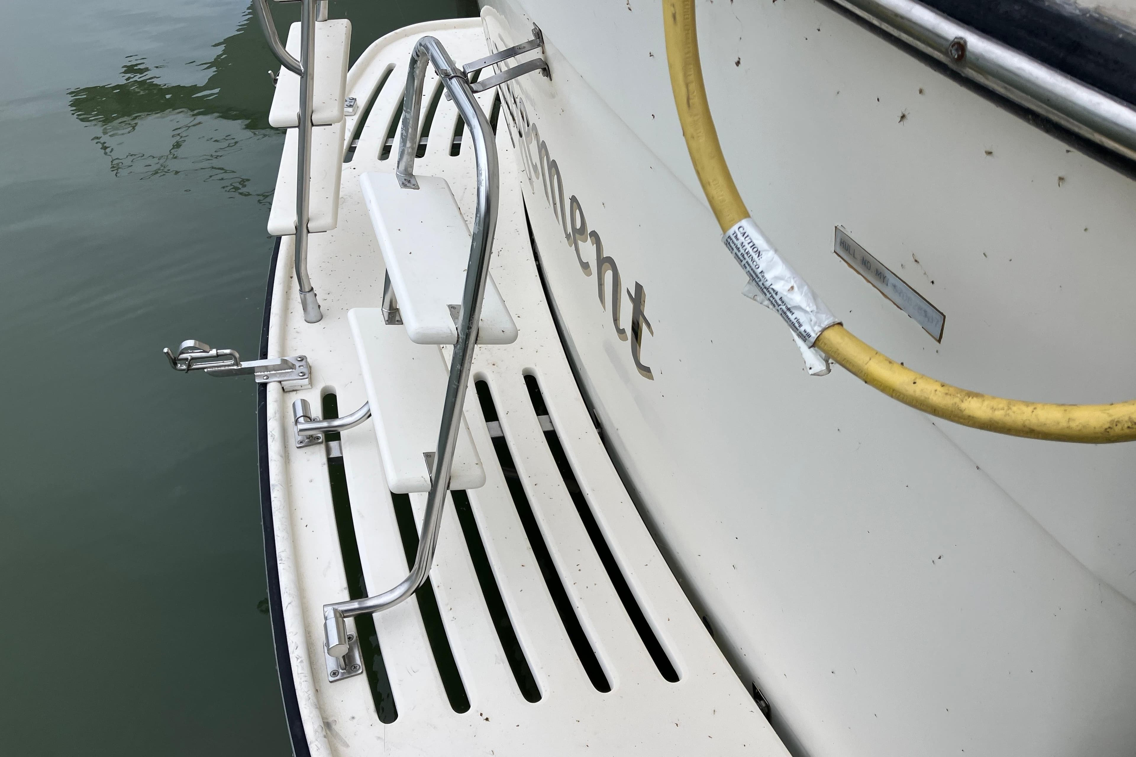 1987 President 37 Sundeck boat stern with ladder and yellow hose.