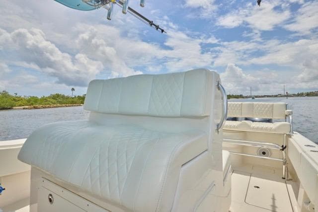 Invincible 36 boat, 2015 model, featuring white cushioned seating on a sunny day.