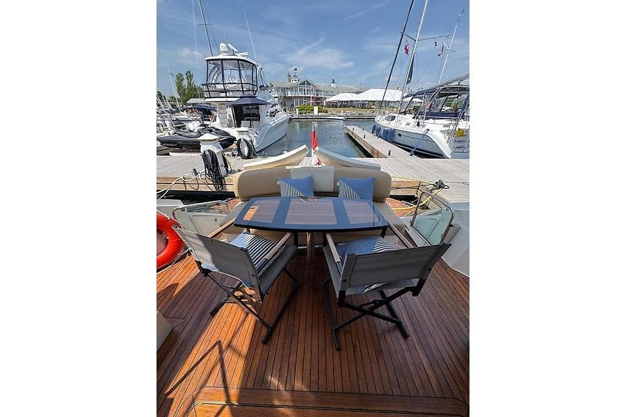 Luxury 2012 Marquis 500 Sport Bridge yacht with elegant outdoor seating at marina.