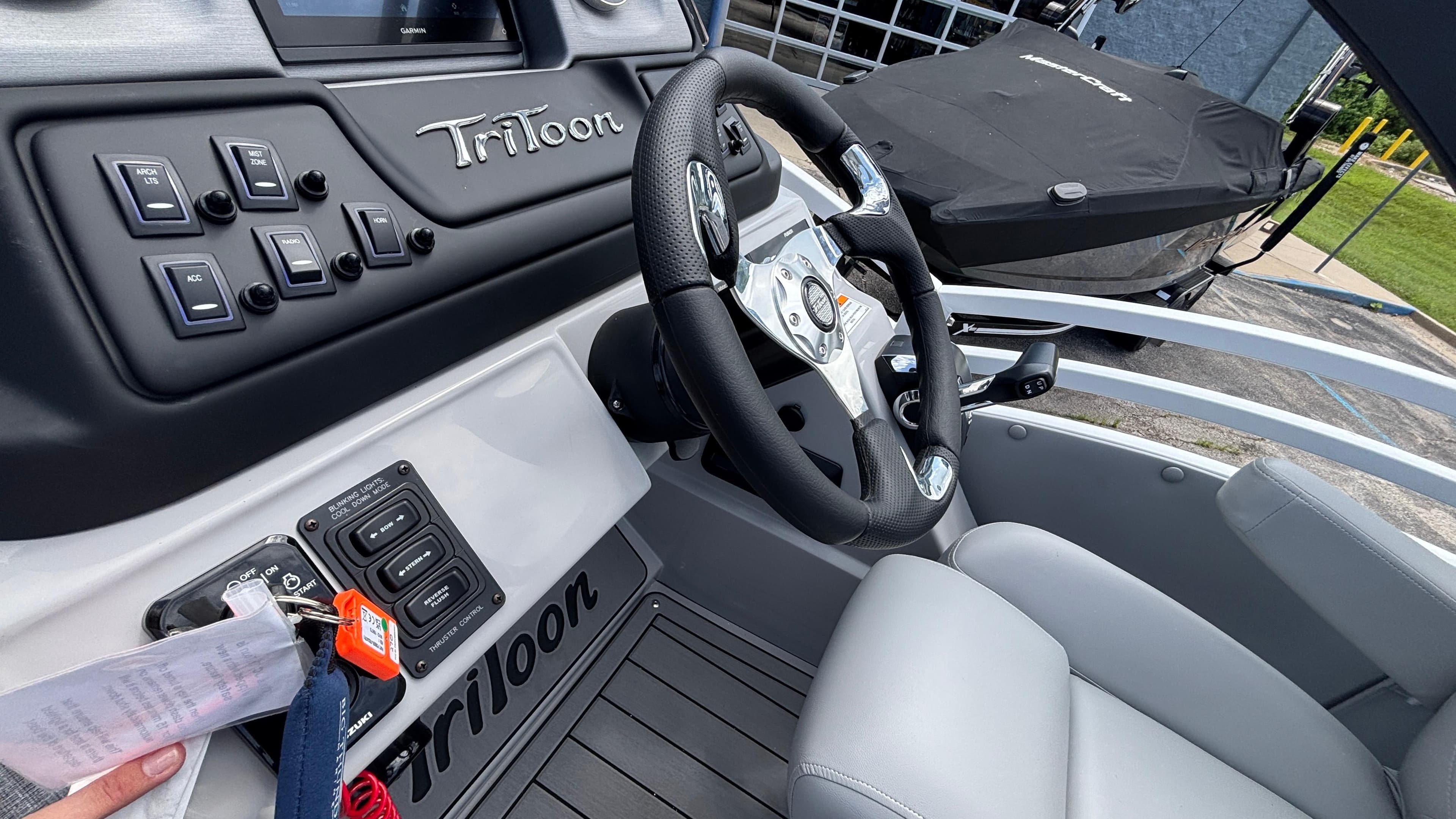 Interior of 2025 JC Neptoon 25TT Sport boat with steering wheel and control panel.