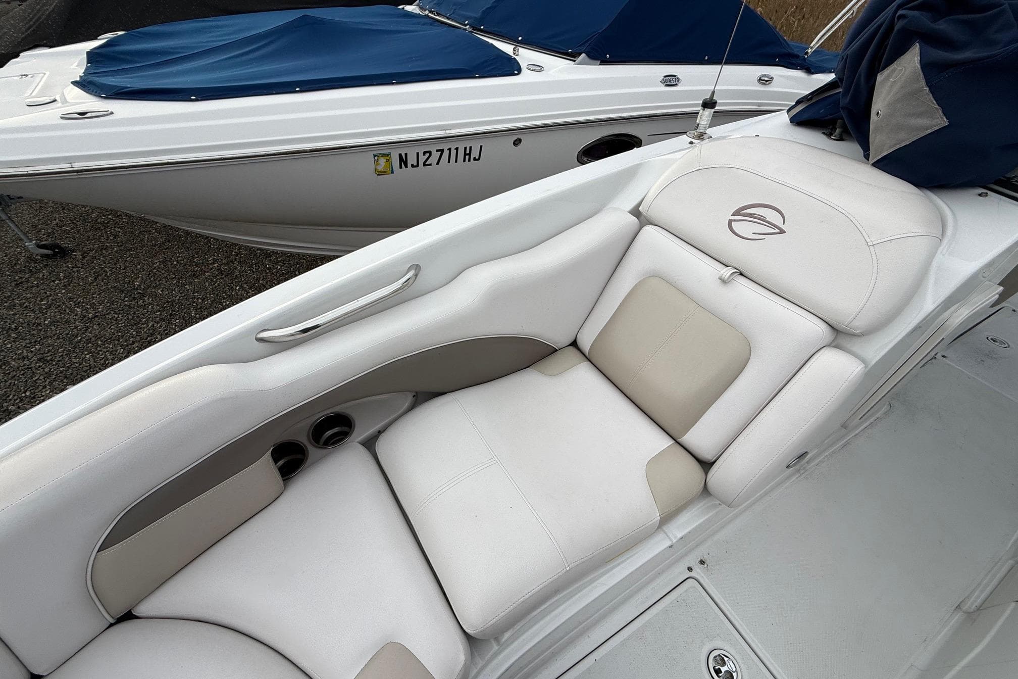 2013 Crownline Eclipse E6 boat with white and beige seating, docked beside another boat.